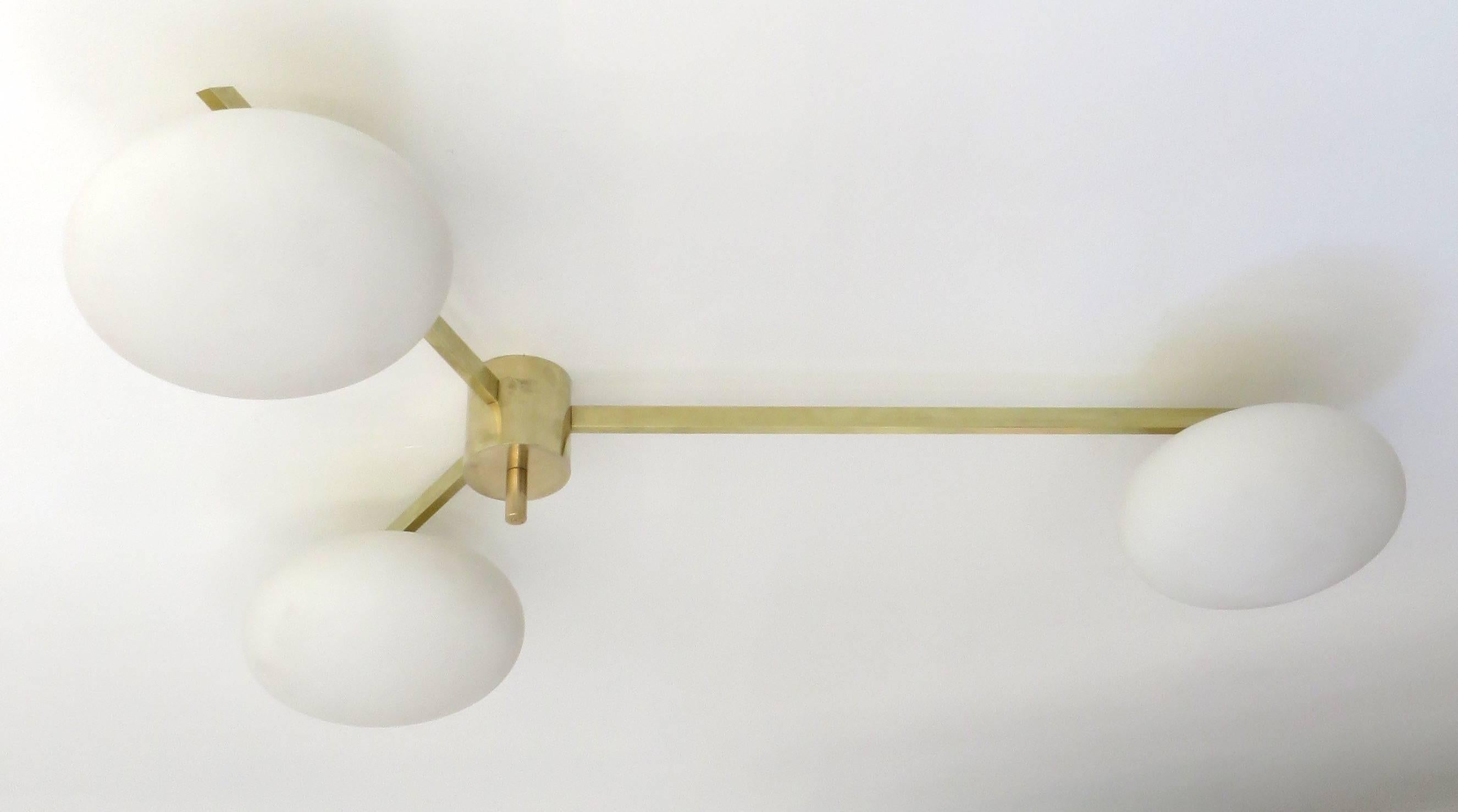 Angelo Lelli Italian three-arm brass and opaque opaline glass ceiling or wall light for Arredoluce, Italy, circa 1950-1960.
Original patina. Signed with makers mark to finial.
Bronze with opaque opaline glass shades. 
Shown in detail shot with