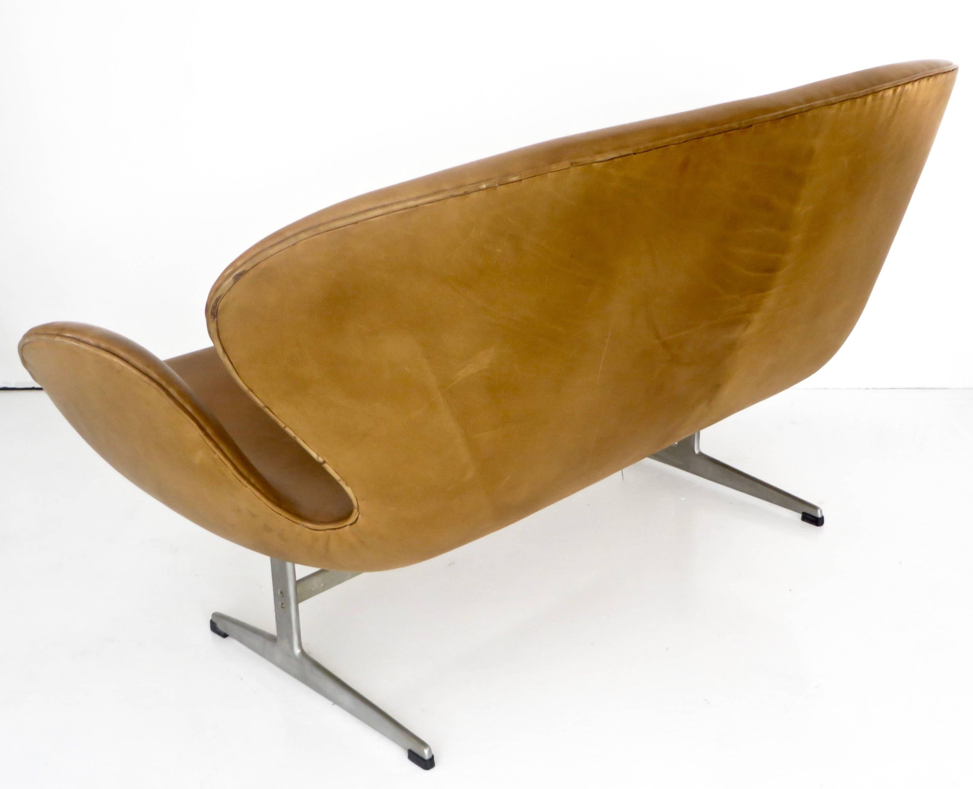 Arne Jacobsen swan settee, Model 3321, Denmark, 1958 signed with applied foil manufacturer's label to underside. FH Made in Denmark by Fritz Hansen 0663 furniture makers Danish control.
Excellent condition caramel color leather, no rips or tears or