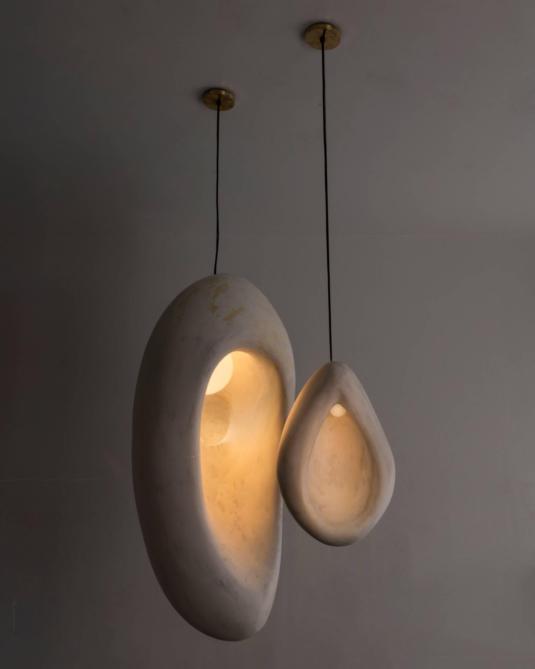 Artist Rogan Gregory hand-carved fertility form sculptural illuminated pendants created with surfboard foam and coated with a gypsum patina.
Influenced by geography, nature and his surroundings of Montauk NY.
Each light is a piece unique. The bulb