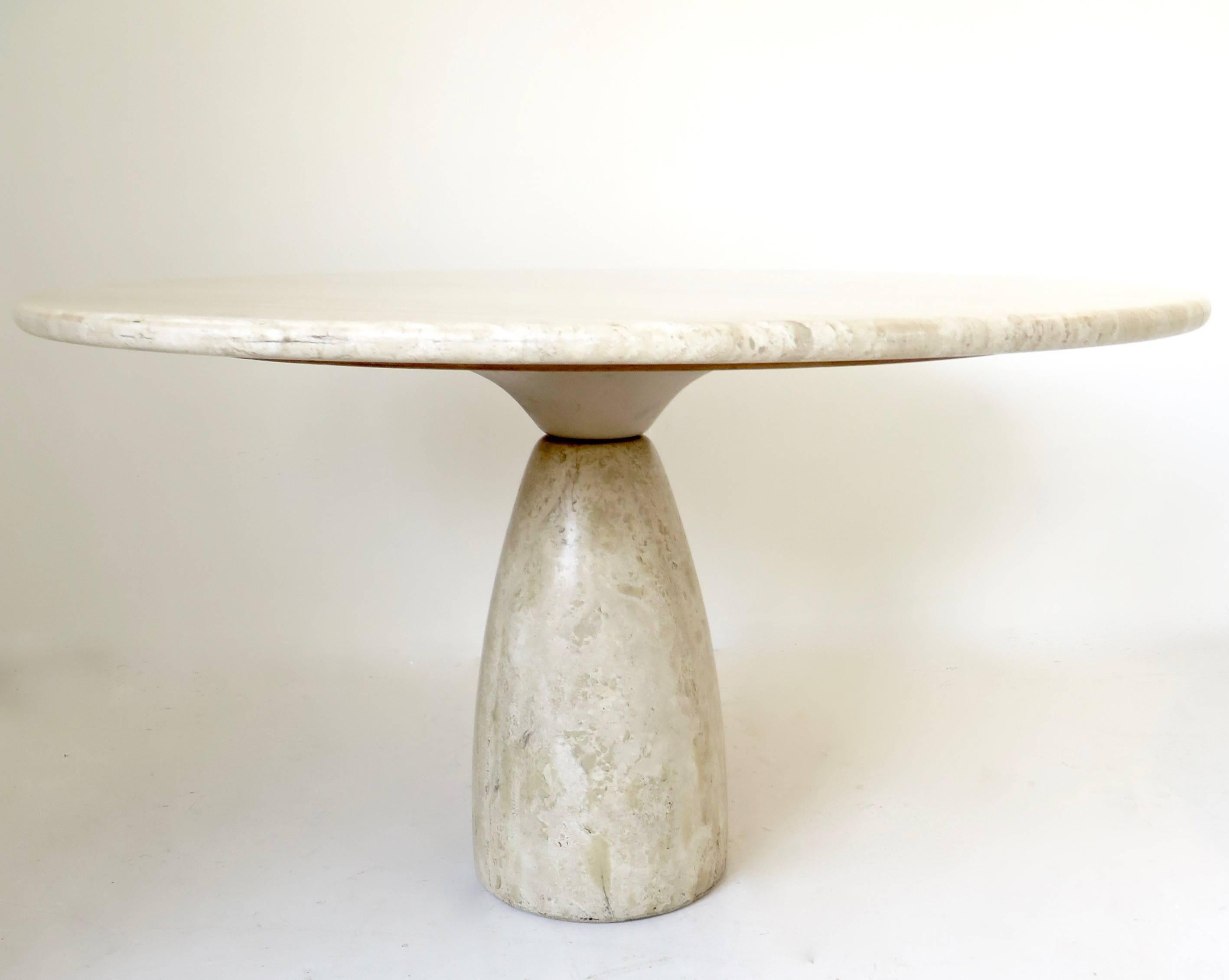 A round 51" diameter top travertine dining or centre table by German designer Peter Draenert.
The pale beige travertine top rests on a tear drop shaped pedestal that is designed with a lacquered metal inverted form that is then pinned to the