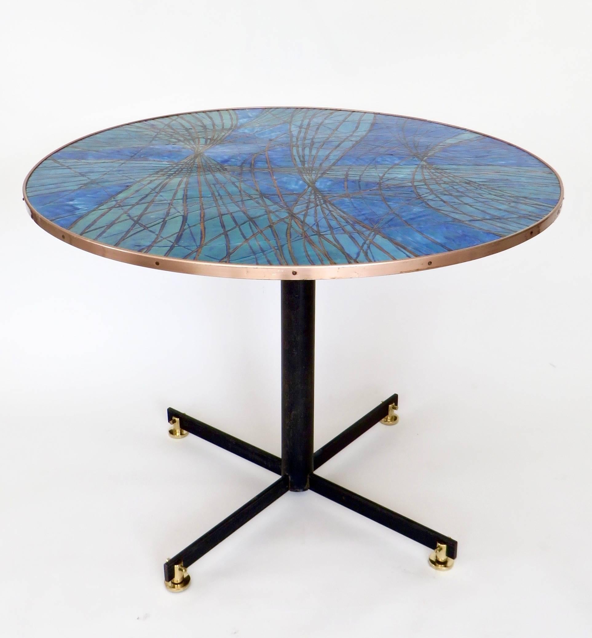 An Italian abstract pattern of enameled gold on Capri blue enamel copper top Italian dining or centre table on amazing black steel legs ending in brass levelling feet. Very Borsani or Albini feet.
A very high quality enamel work that is very