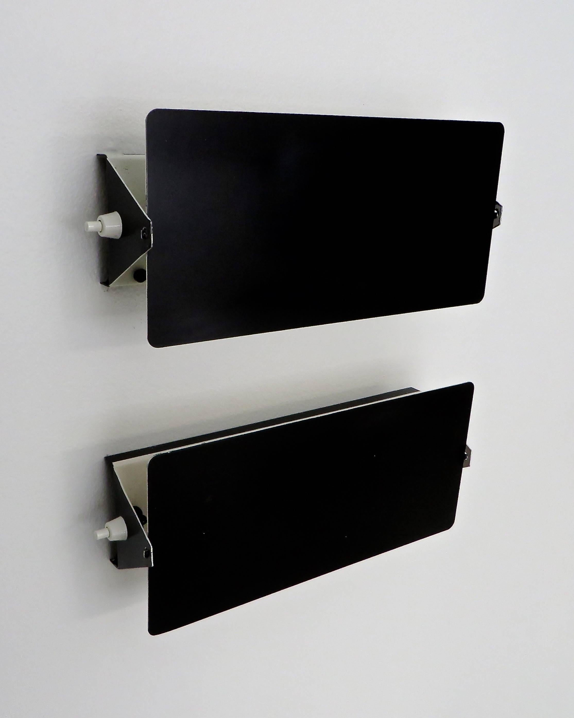 Charlotte Perriand double socket vintage CP-1 sconces, Steph Simon edition, Paris, France.
The iconic black enamel outside with white interior and black sockets from Les Arcs ski resort. 
Original finish and sockets and switches. Five single