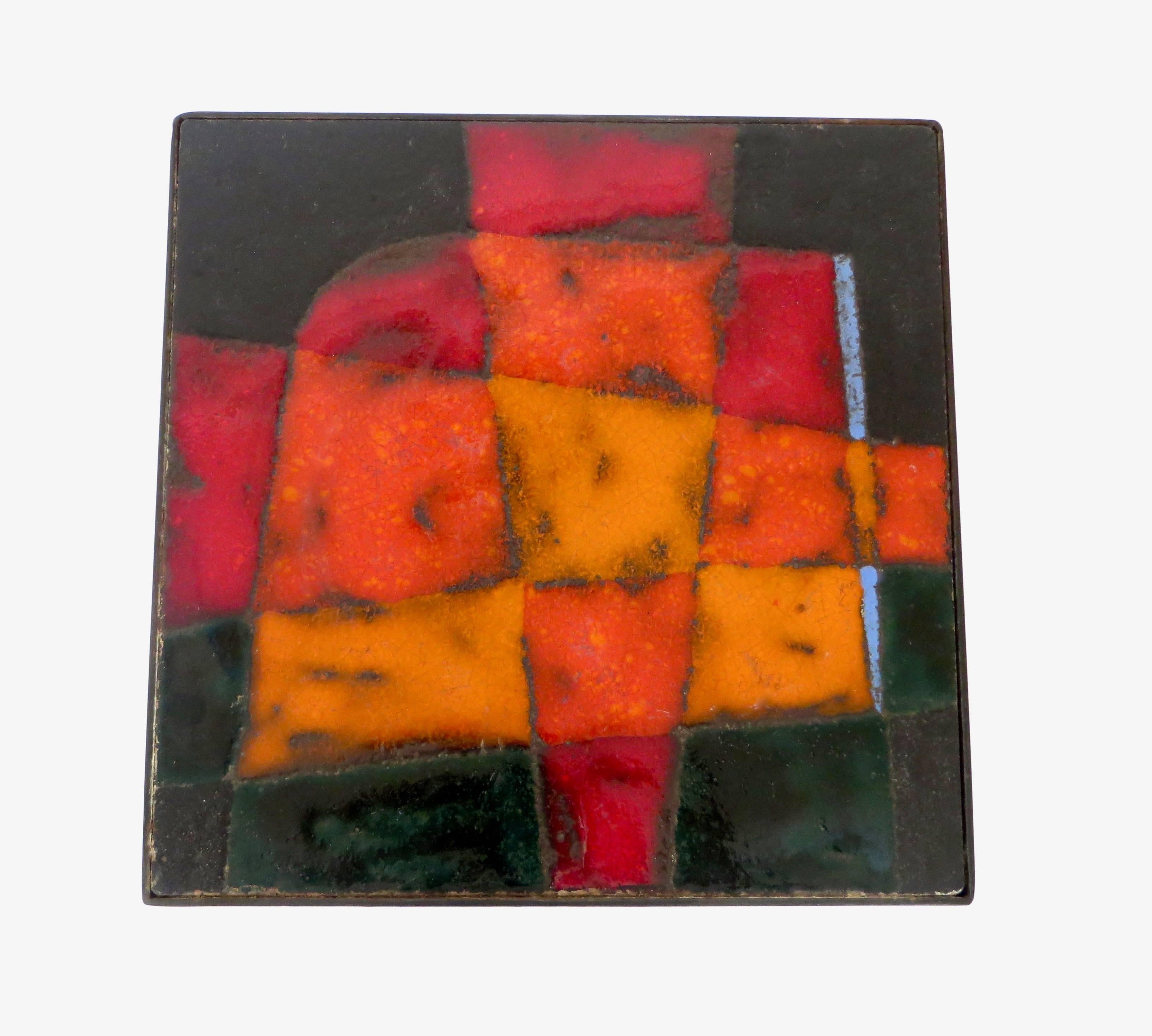 A boldly colorful and graphic ceramic tile glazed top with black metal leg structure, circa 1960, France. Colors of orange, red, black and touches of blue by Jean and Robert Cloutier.   
Documentation: Les Freres Cloutier written by Patrick