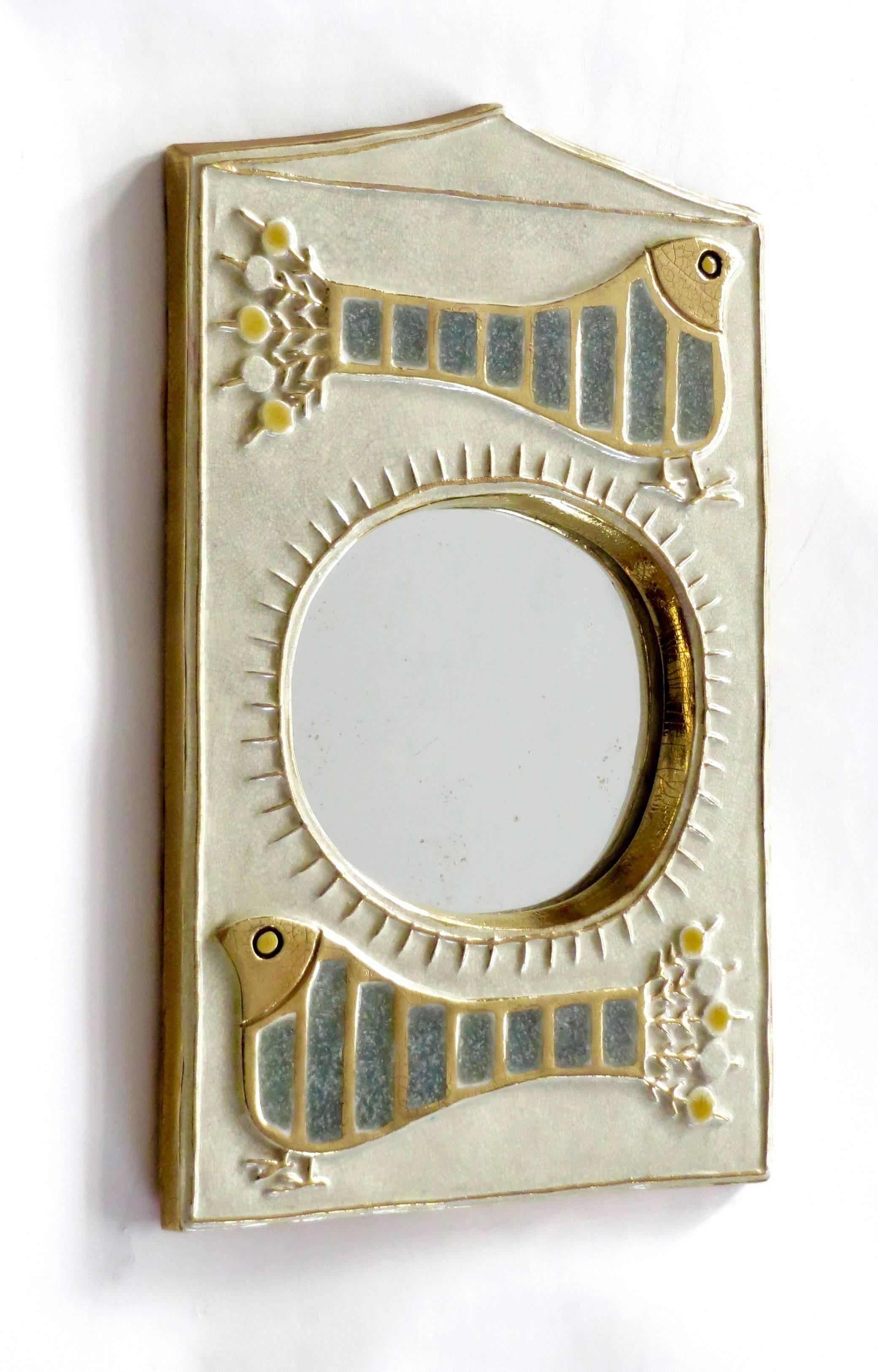A French ceramic mirror by Francois Lembo with stylized bird motif and sun motif.
Very pale blue and green colors with iconic gold Limbo glaze on a creamy white glazed background.
Back in typical felt of Lembo.
Excellent condition with no chips or