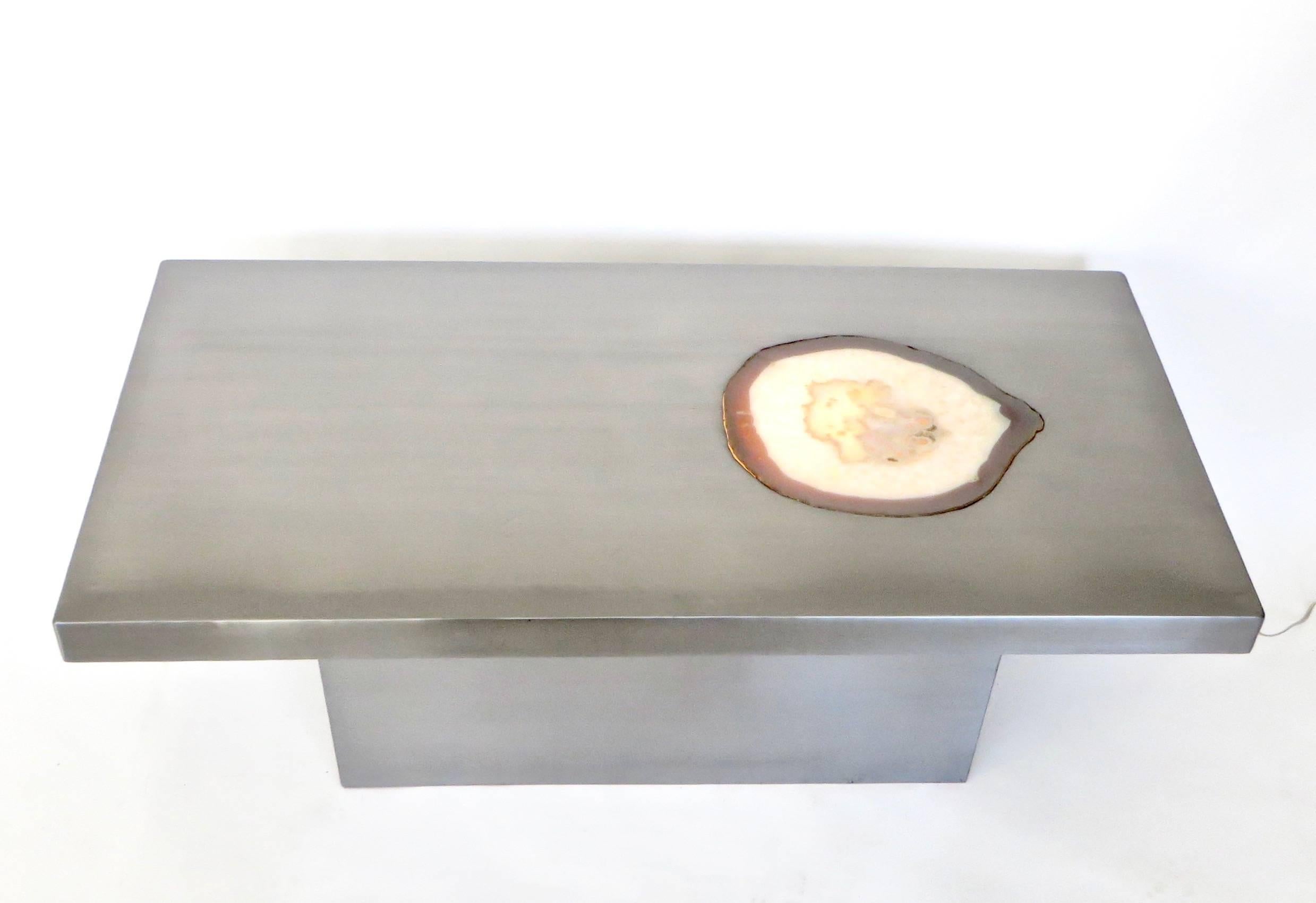 French stainless steel rectangular coffee table with a large agate inlaid into the top plateau surface with illumination from underneath.
The top plateau is permanently joined to the rectangular base.
In excellent condition and in a very