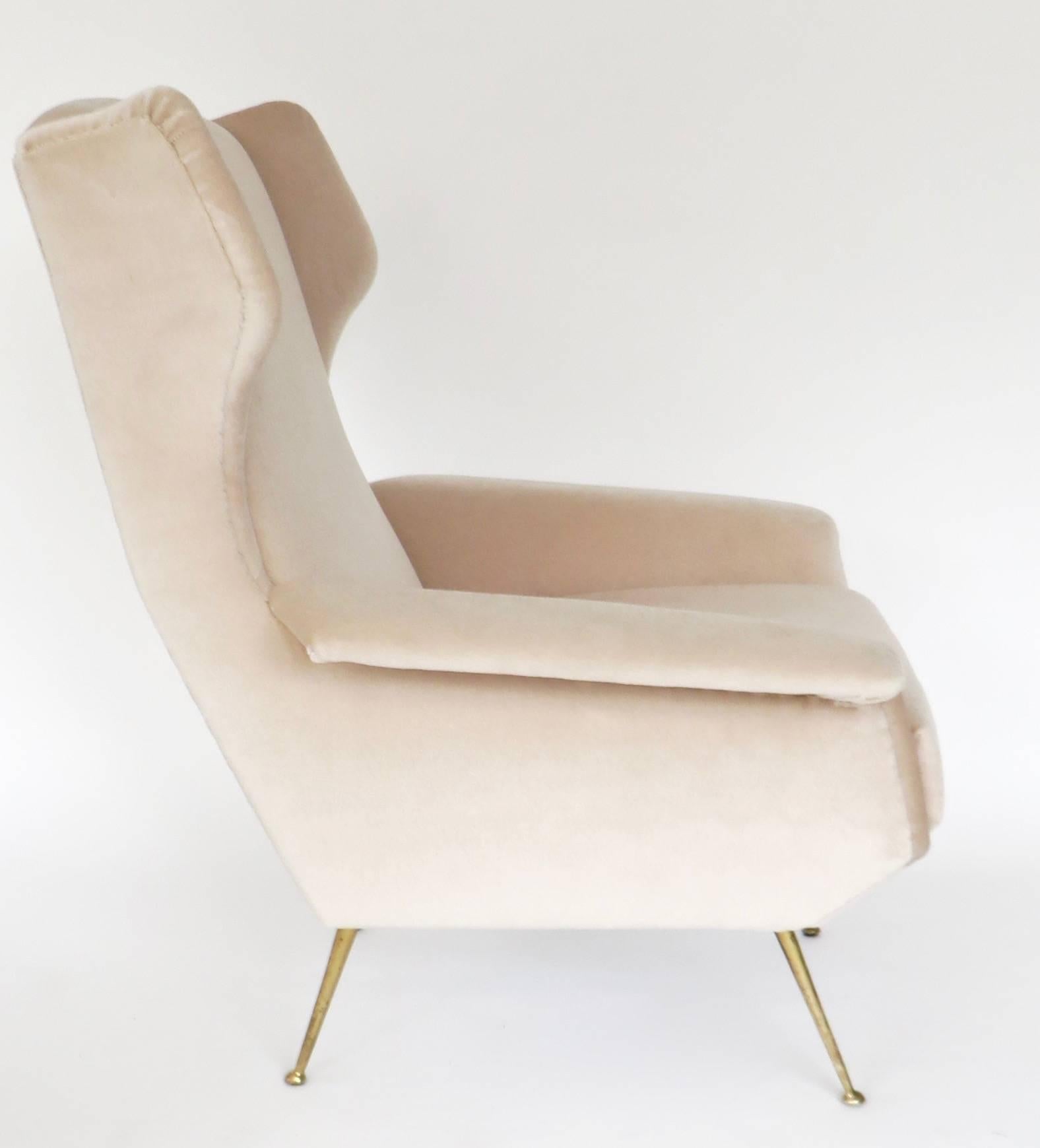 An Italian wingback lounge chair with arms featuring brass legs and brass feet reupholstered in a pale pale cream pink silk mohair. 
Measures: Overall size: 31