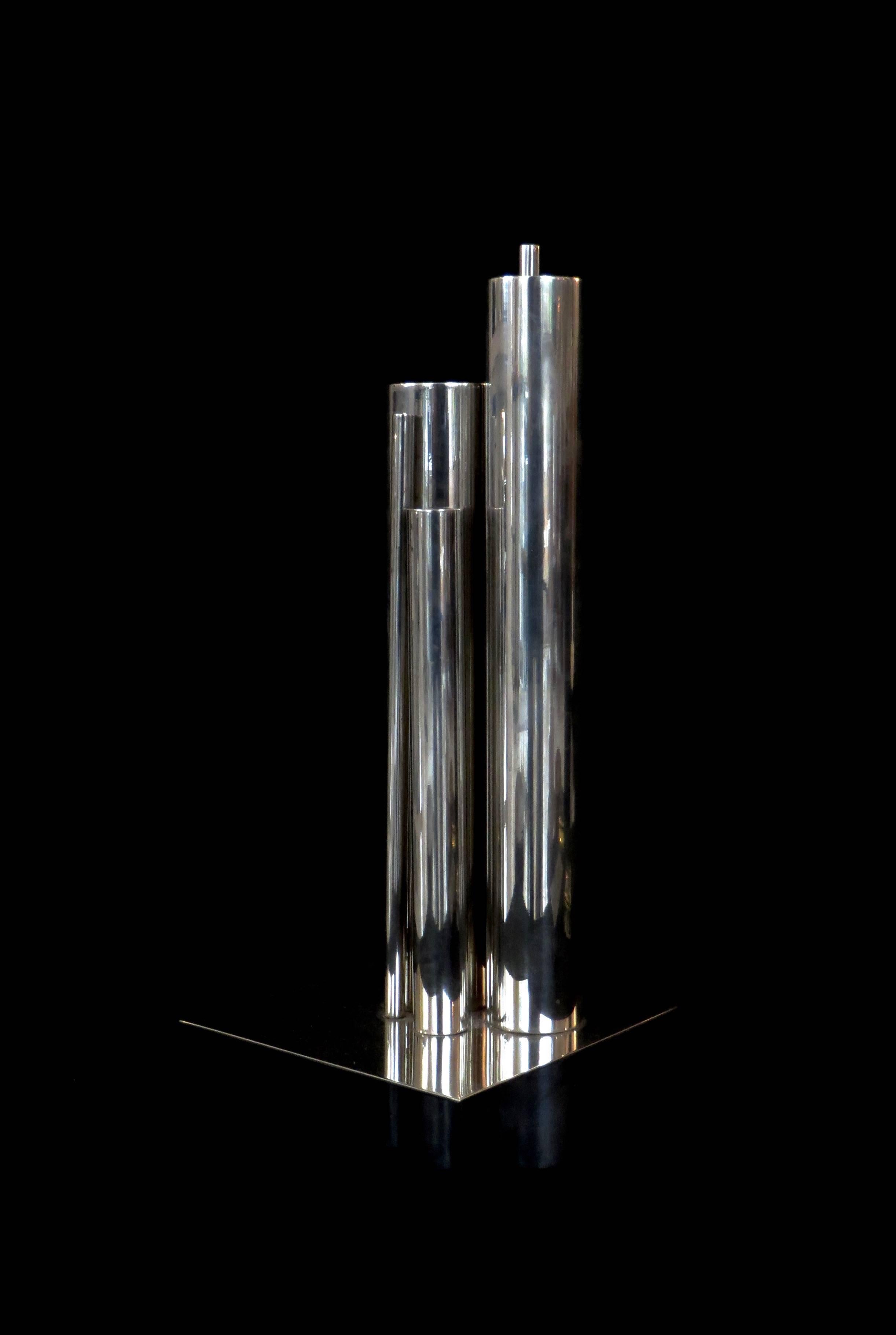 The Jacques Sitoleux vase comprising tubes in varying heights and diameters grouped together and raised on a thin plate, all in silver plated brass. Sometimes referred to as the Polivaso.
Stamped with manufacturer's hallmark to one of the tubes. 
