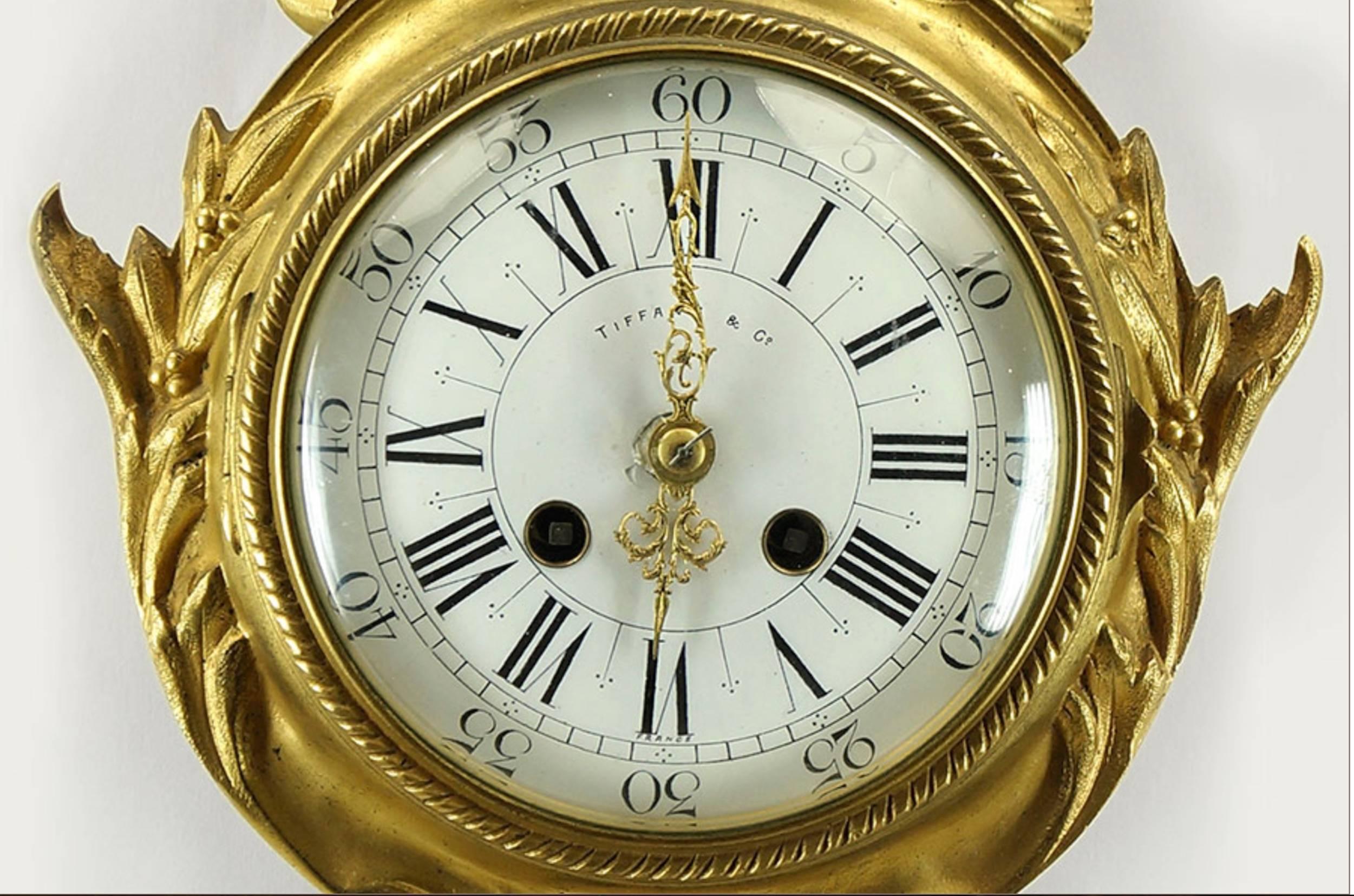 A Tiffany & Company gilt bronze Cartel clock, enamel with Roman numeral dial reads 
