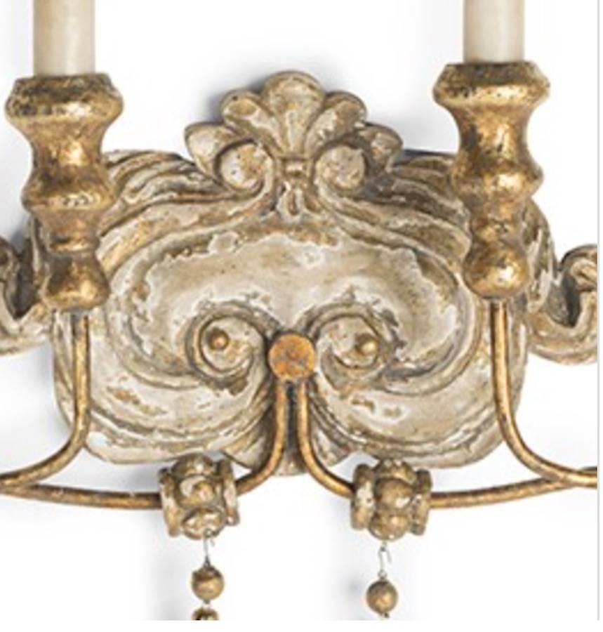 Elegant set of six Italian style two-arm sconces with lovely worn painted and gilt finish. Newly wired so installation ready. Note: Priced per sconce.