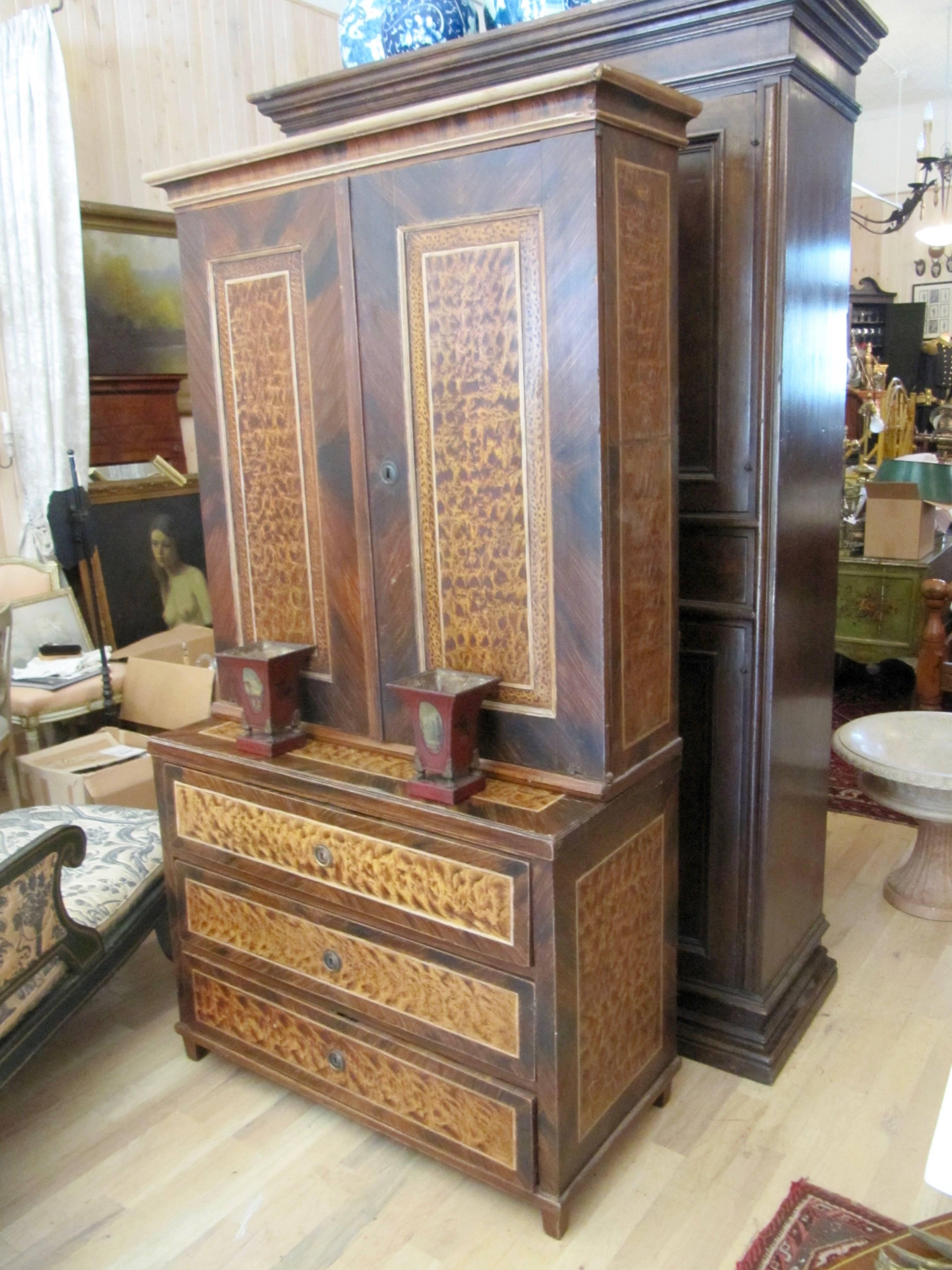 Sale 449 lot 1038.

An American faux bois step back cupboard, 
first half of 19th century.
in two parts, the upper section having a molded cornice over two paneled doors, the lower section enclosing three long drawers raised on square tapering