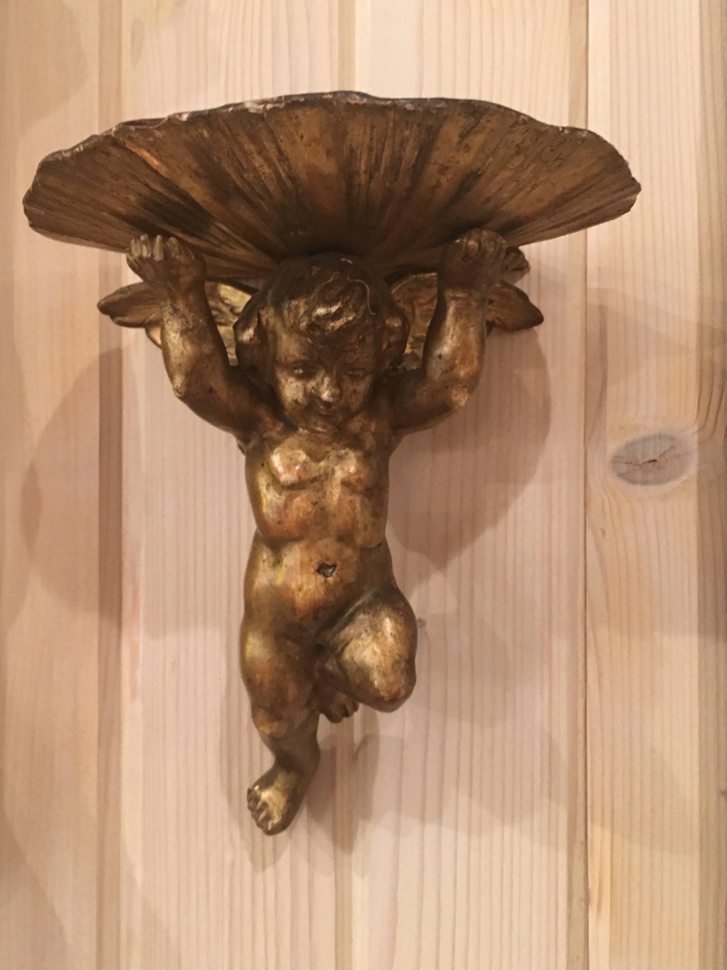 Charming pair of 19th century Italian giltwood brackets, putti supporting shell shelf. Great color, patination. Confirm measurements.