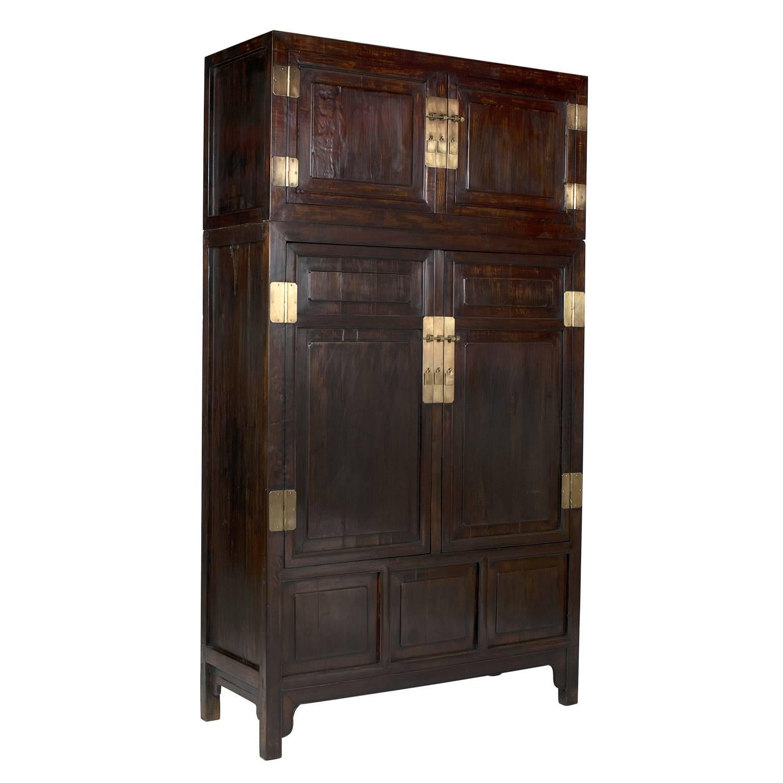 A highly skilled Chinese artisan constructed this pair of stacked compound cabinets. Each is perfectly proportioned with clean lines, carved paneled doors, hand-forged brass hardware and complex joinery. Traditional Chinese homes didn’t have closets