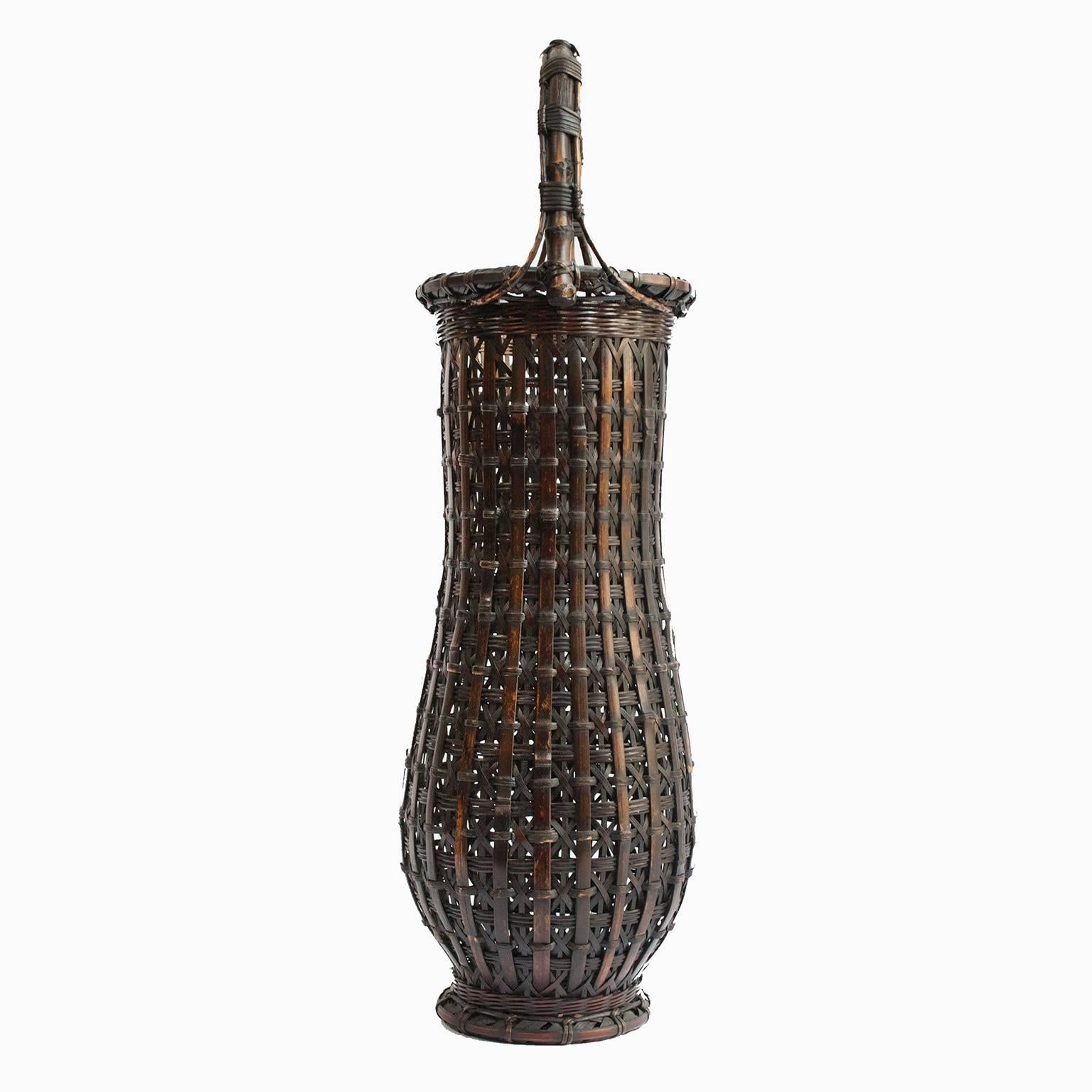 This one-of-a-kind bamboo basket was designed to hold ikebana: a very special Japanese flower arrangement. Looking at the detail of the weave, which resembles a knot, at the very center of the top of the handle indicates that the artisan who made