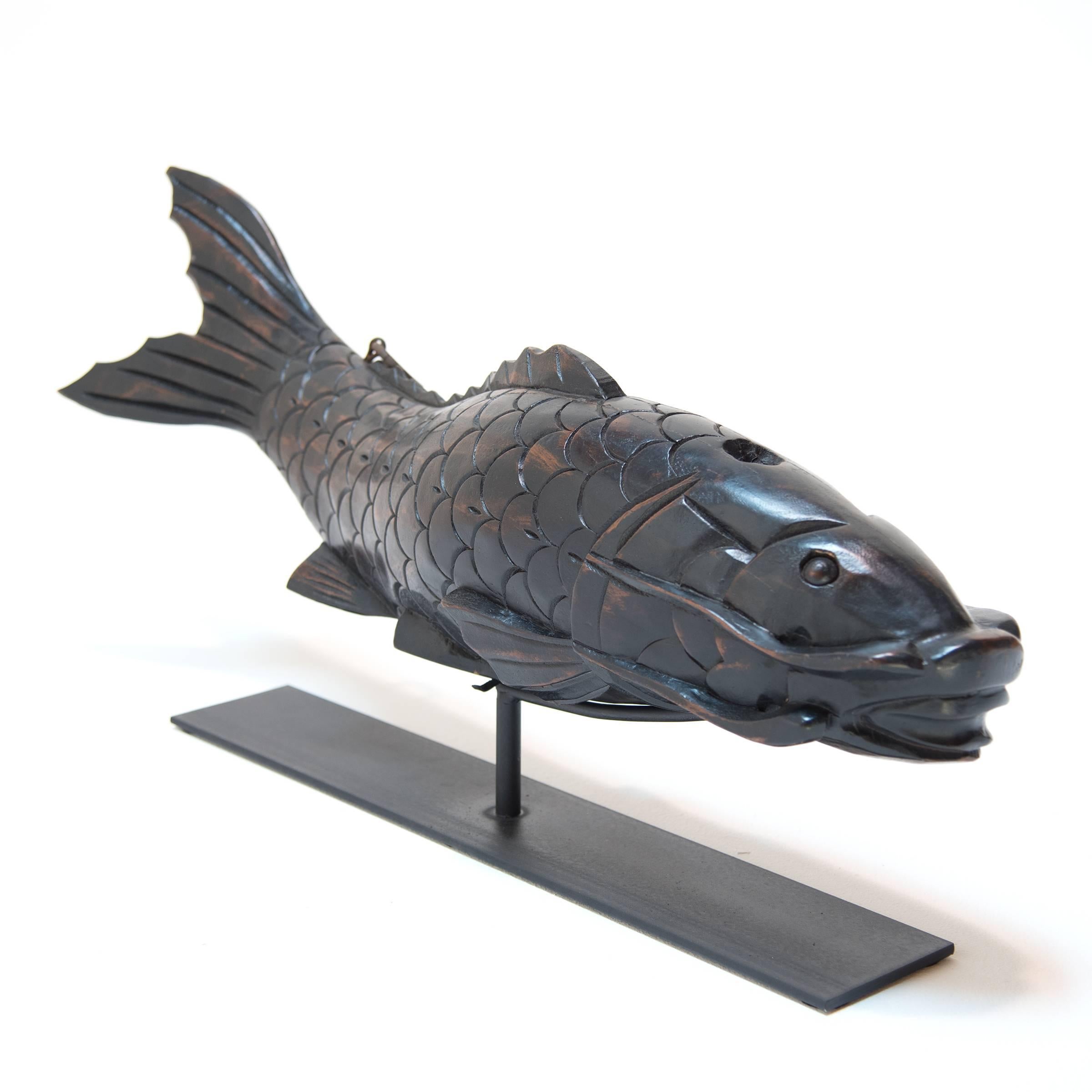 This 19th century carved koi was originally hung outside a fish market as a shop sign.  It has intricately carved scales and whiskers and is mounted on a custom iron stand.  We love it for its fluid expression.