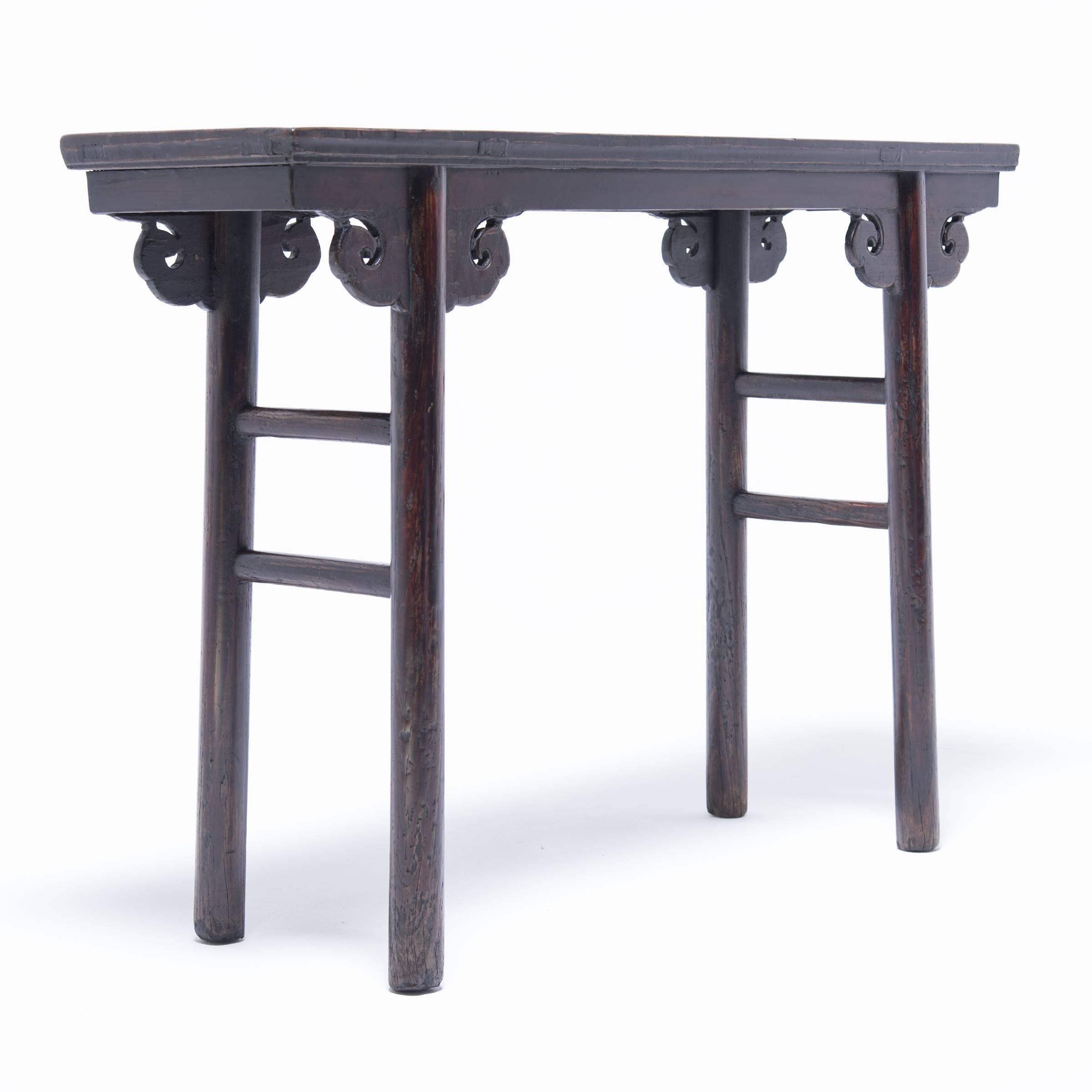 This exquisite elmwood shallow wine table has simple stretchers, inset legs, and scrolled spandrels. It was commissioned in China’s Shanxi region over one hundred and fifty years ago when wealthy bankers and merchants who lived in the area