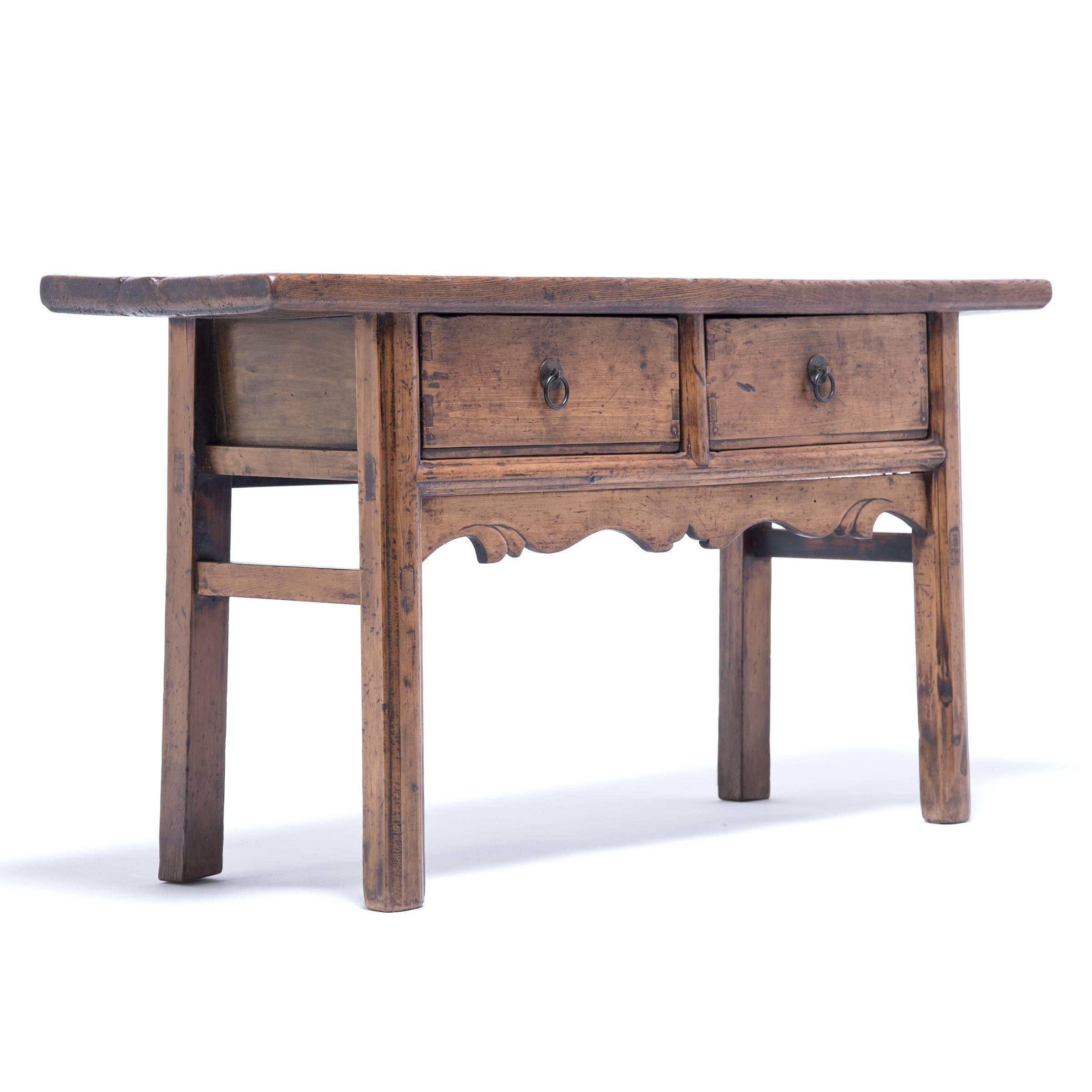 This provincial 19th century table was made by hand with lyrical lines and classical proportions. It stands pure, simple and proud and is easily identified by its arched and cusped apron. The double drawers were opened many times to retrieve curios,