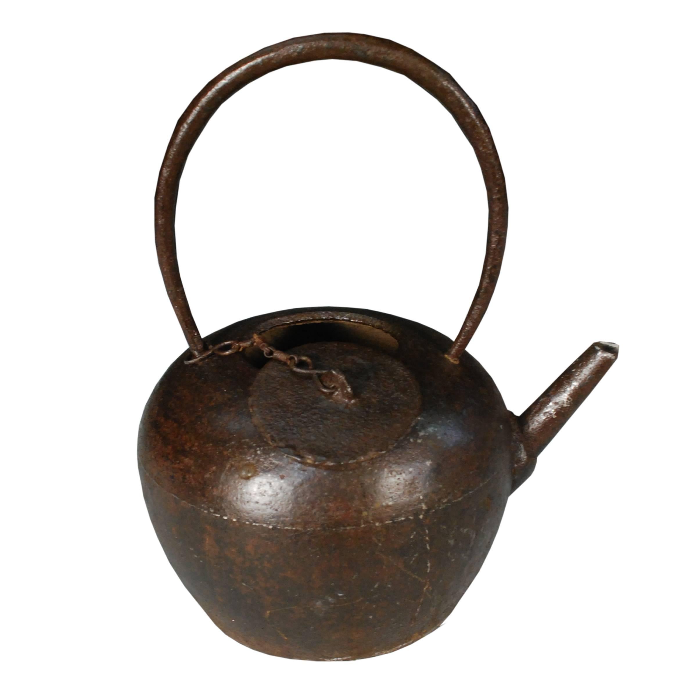 This round sculptural iron teapot was cast in Northern China during the late Qing dynasty. Earlier teapots were generally large, but connoisseurs eventually discovered that smaller pots, like this one, hold the aroma of tea better and stop the