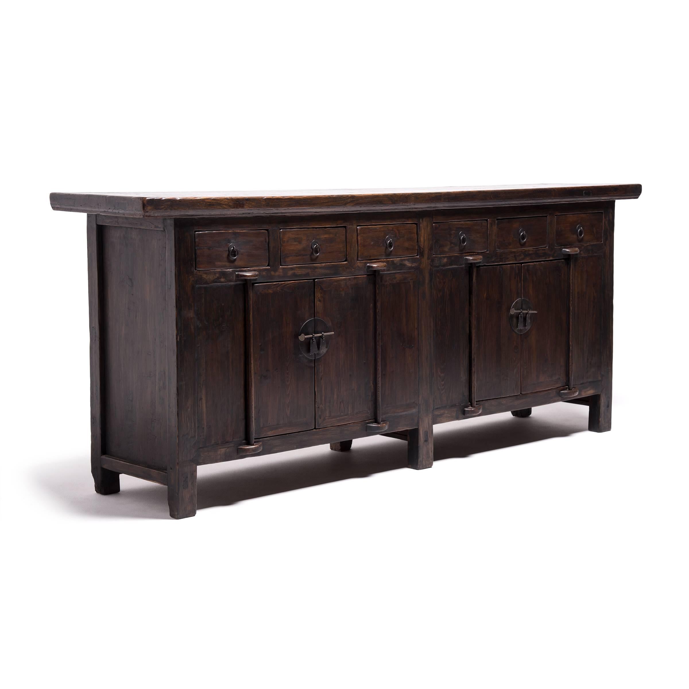 Constructed without screws or nails, this elegant coffee tops two cabinets with a row of four small drawers, appointed with ring pulls and decorative latches with dagger posts. Dating from circa 1815 during the latter half of the Qing dynasty, the