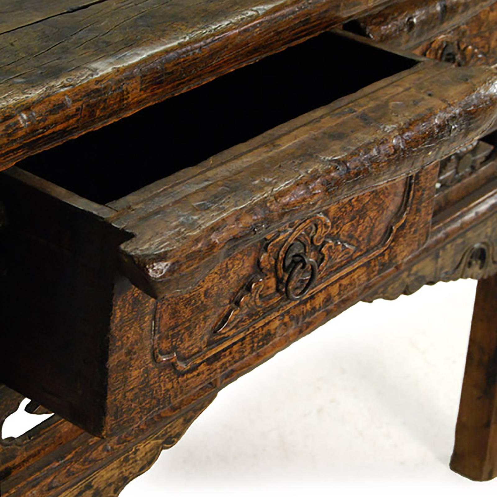 There are two drawers made of burled elmwood cleverly hidden in the apron of this 19th century. Provincial incense table, carved in an ornate archaic style and likely used to hold incense. The table maintains a wonderful spirit, with a beautifully