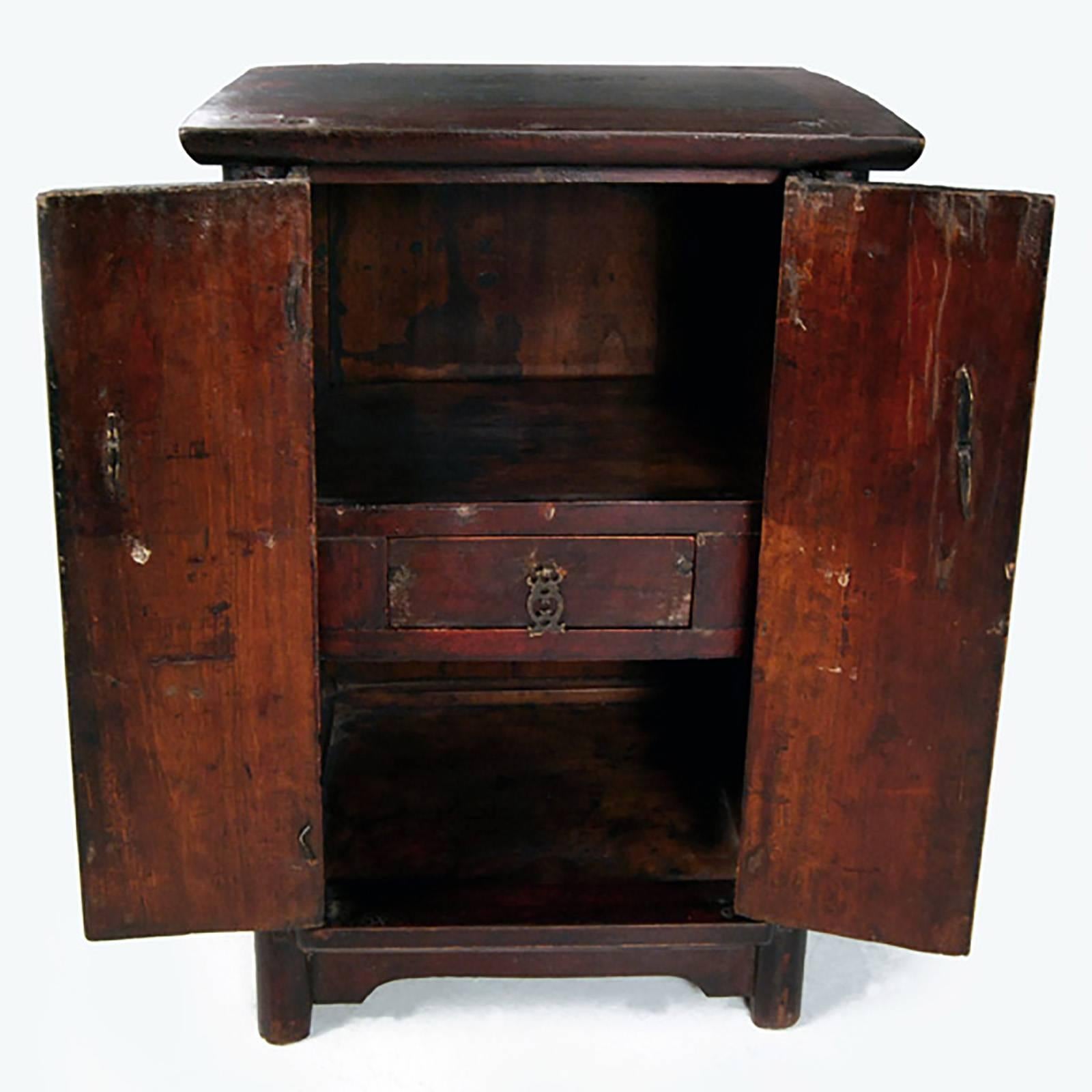 Made of northern elmwood, this petite 19th century two-door cabinet was likely created as a carpenters sample to show how joinery and timbers come together in a traditional Chinese wedding dowry cabinet. The original brass plate that would have been