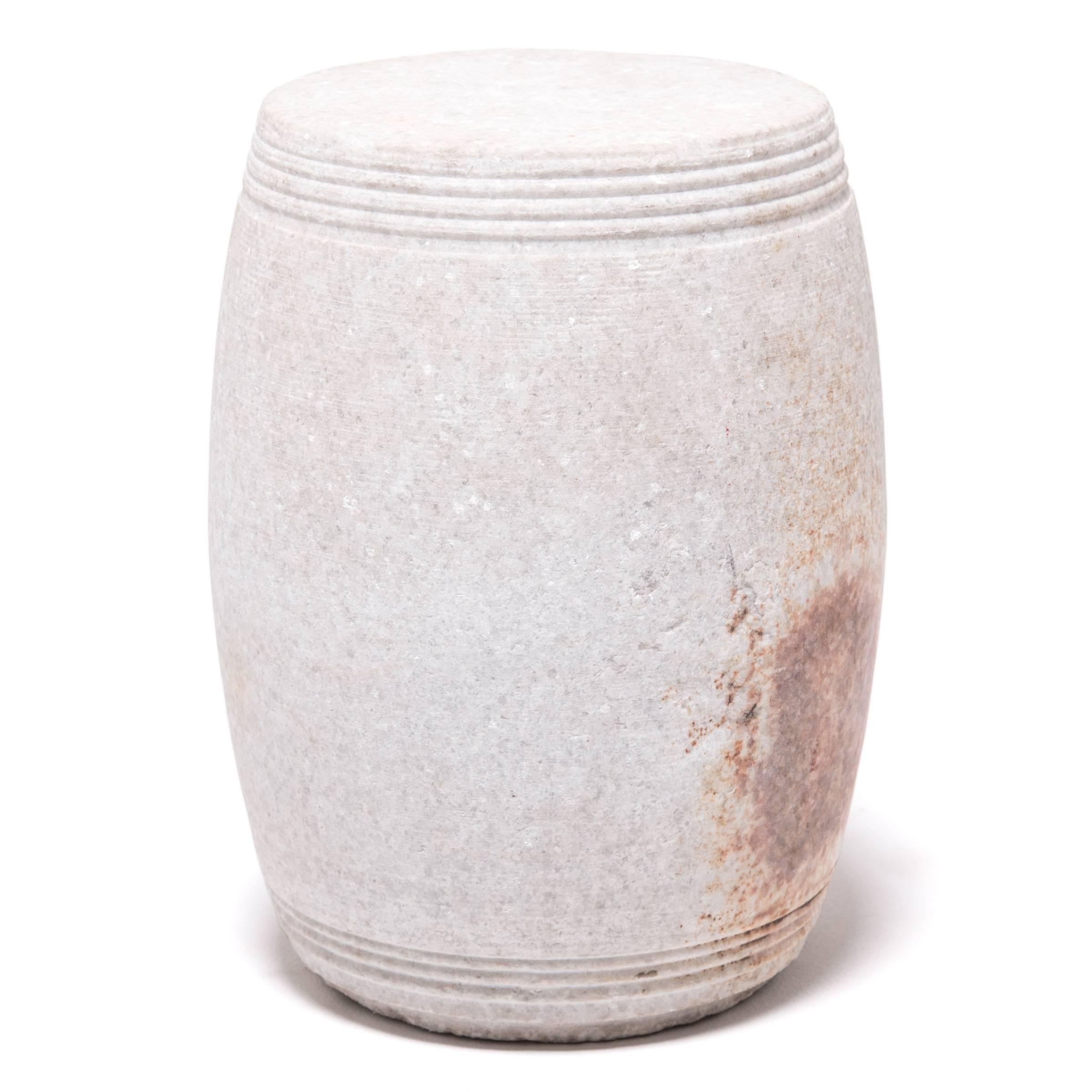 This drum-form object is carved from a single piece of marble. Around the top and bottom are delicate, incised concentric ribs. Stone furniture like this was commonly placed in Chinese gardens and courtyards to reduce the amount of indoor furniture
