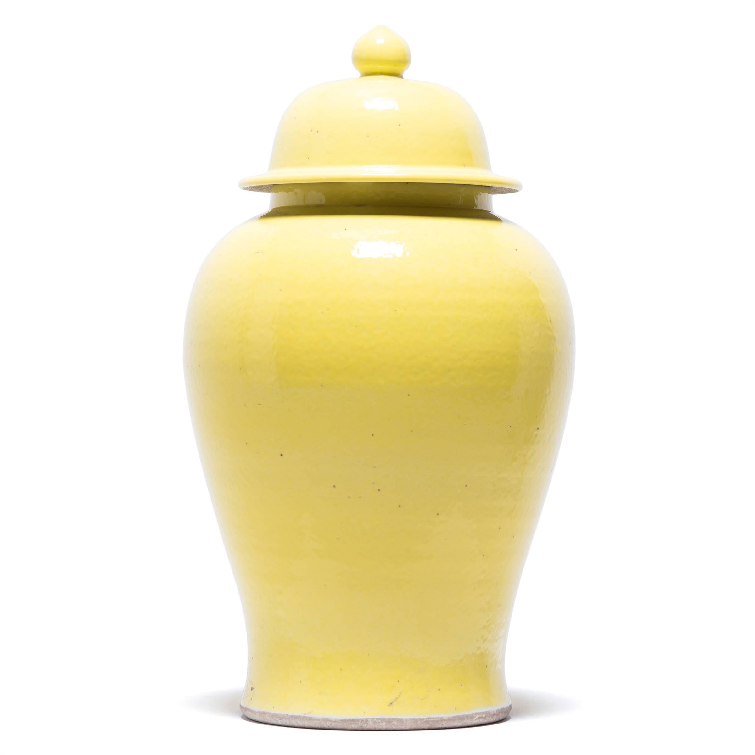 Defined by its rounded body, high shoulders and domed lid, the time-honoured look of the Chinese baluster jar is streamlined as a monochrome. This artisan made modern take on a Classic is cloaked in a simple, cheerful citron glaze to call out its