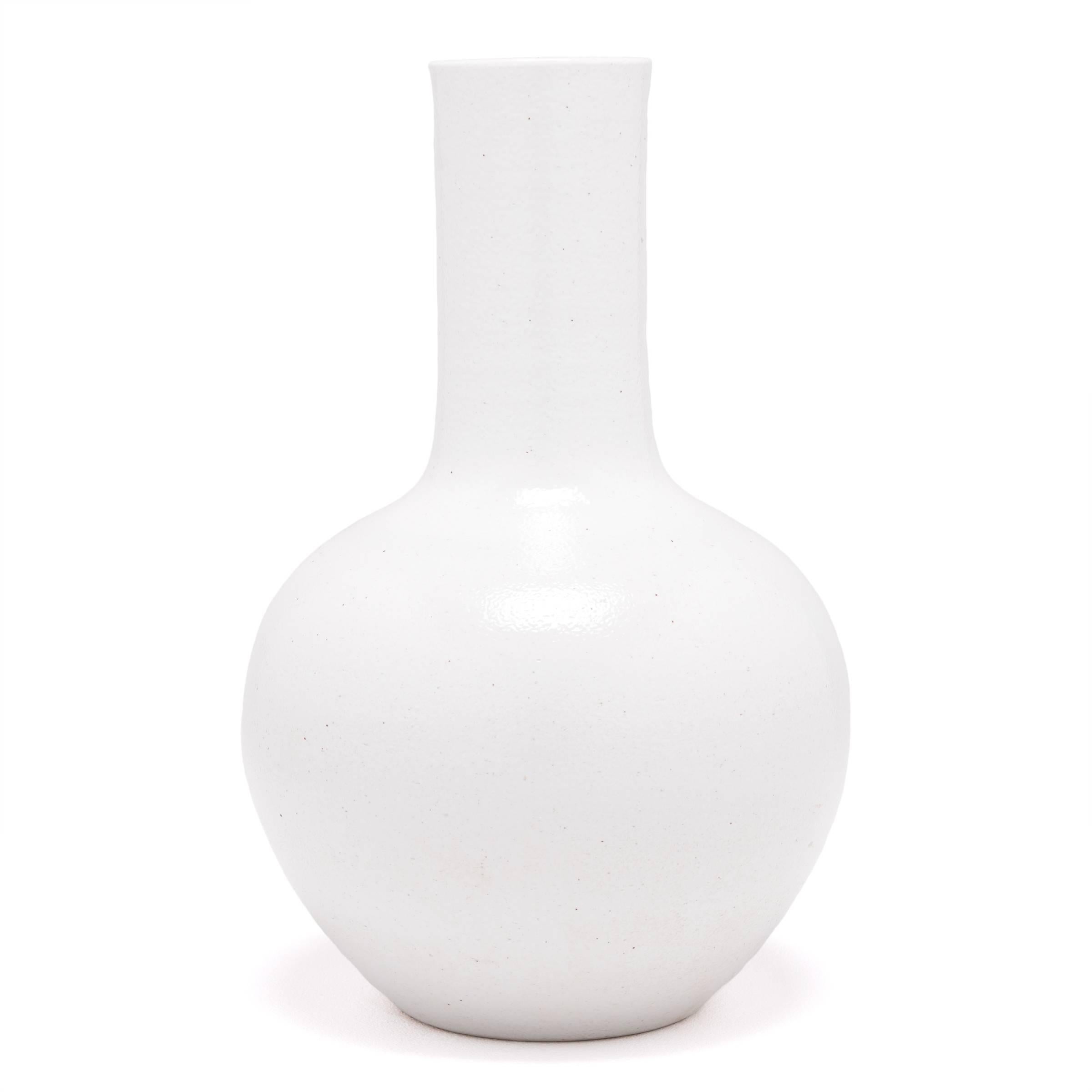 Drawing on a long Chinese tradition of monochrome ceramics, this austere long-necked vase is glazed in serene, cloud-inspired white. Crafted in in Jiangxi province, local ceramists reinterpreted this very traditional shape with clean lines and an