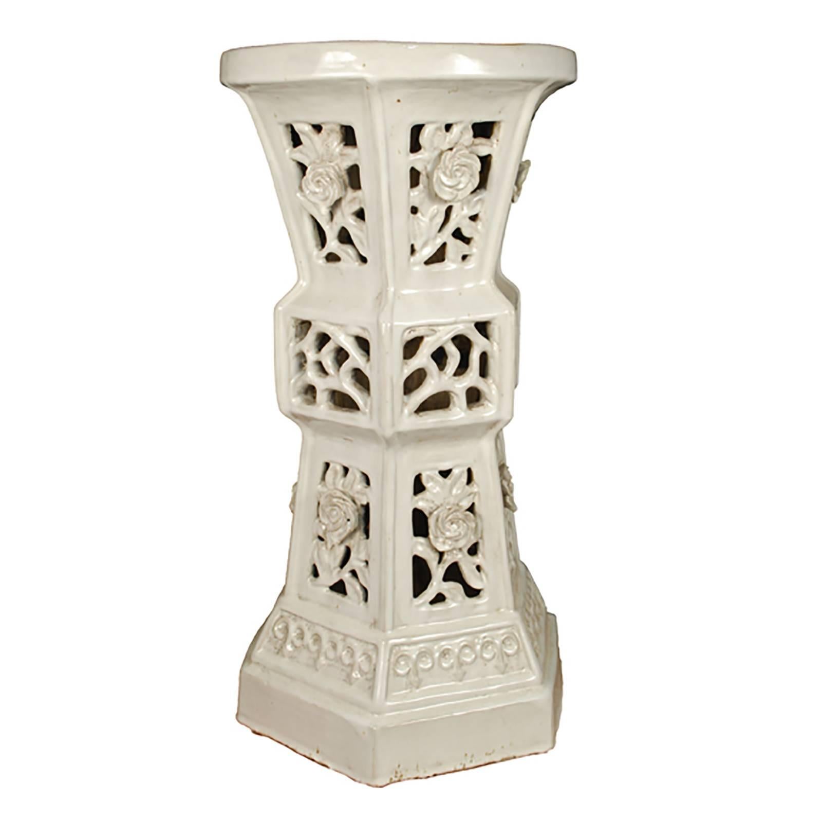 This unusual early 20th century white glazed ceramic pedestal was made by an artisan in Southern China and features an hourglass form and floral cut-outs. It's height indicates it was likely used in a garden for incense, tea or plants but, today,
