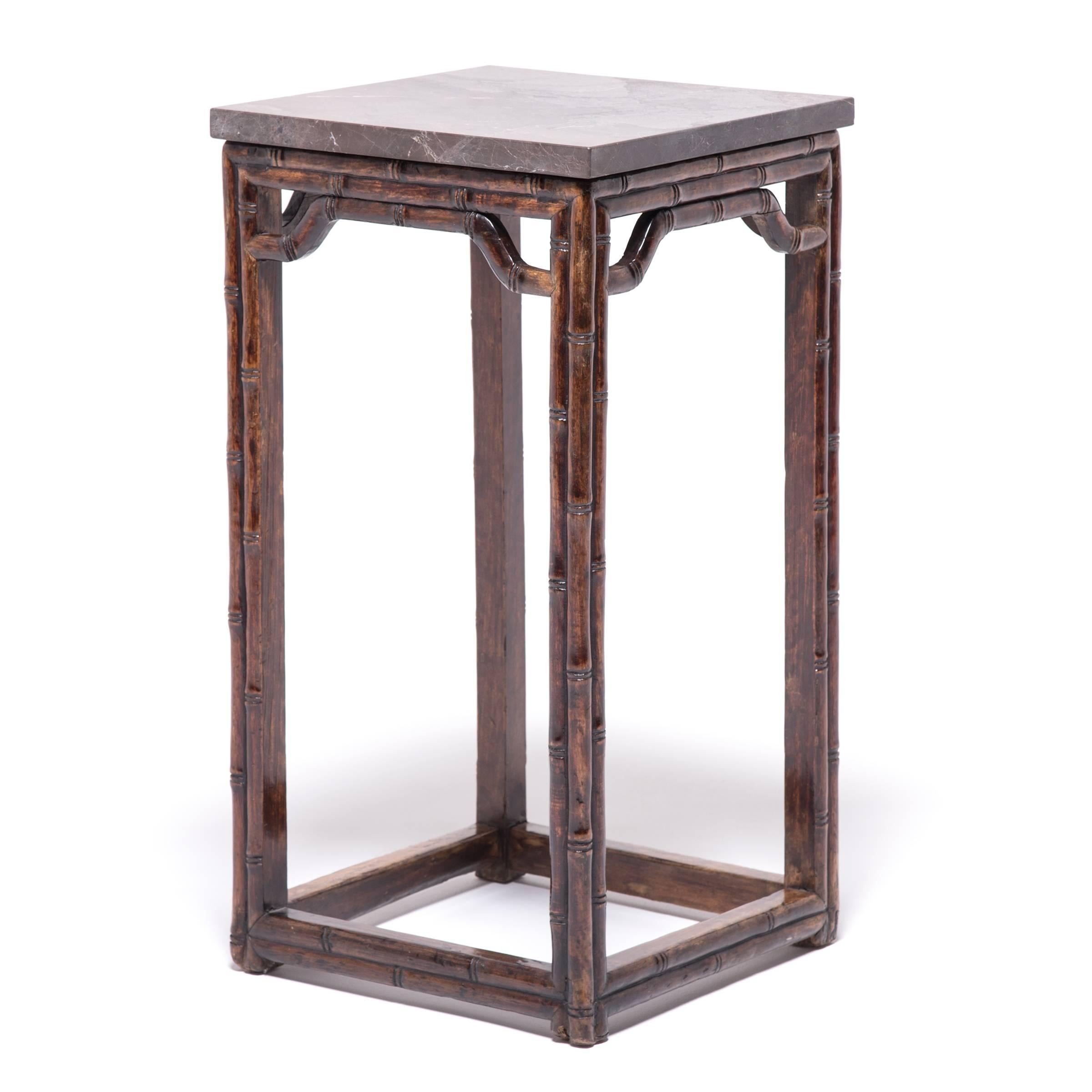 Sculpted by a 19th century carpenter to resemble bamboo, this fruitwood tea table expresses the virtuous characteristics of bamboo, integrity, strength, and perseverance. First popularized in the 17th century, this style emulates bamboo furniture