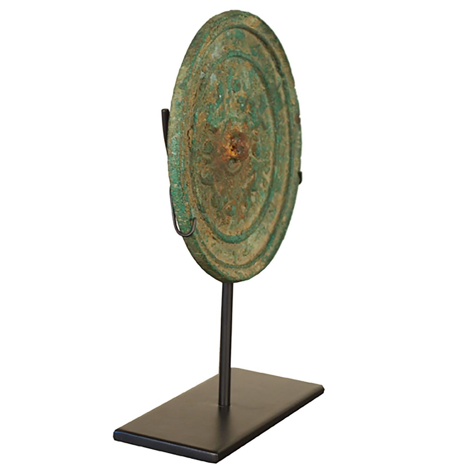 Dating circa 800 AD, during the Tang dynasty, this bronze mirror has developed a beautiful green patina that brings into contrast its embossed running dog motif. This mirror came from the Todd Collection, the foundational 1,000 piece bronze mirror