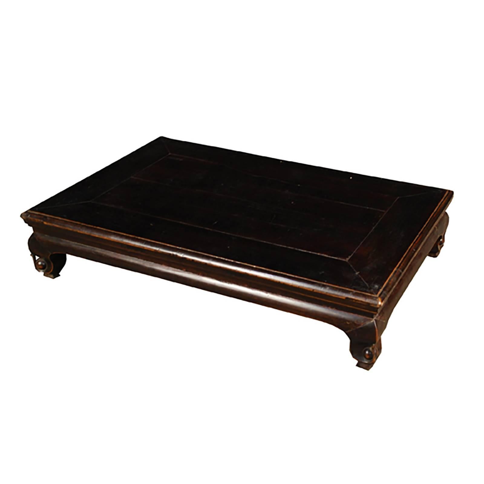 The low-lying kang table, a kind of daybed, provided not only a place to retire but also a space to share tea, a game, or conversation. Deceptively simple, this 19th century table made of northern elmwood reveals its handcrafted artistry in petite