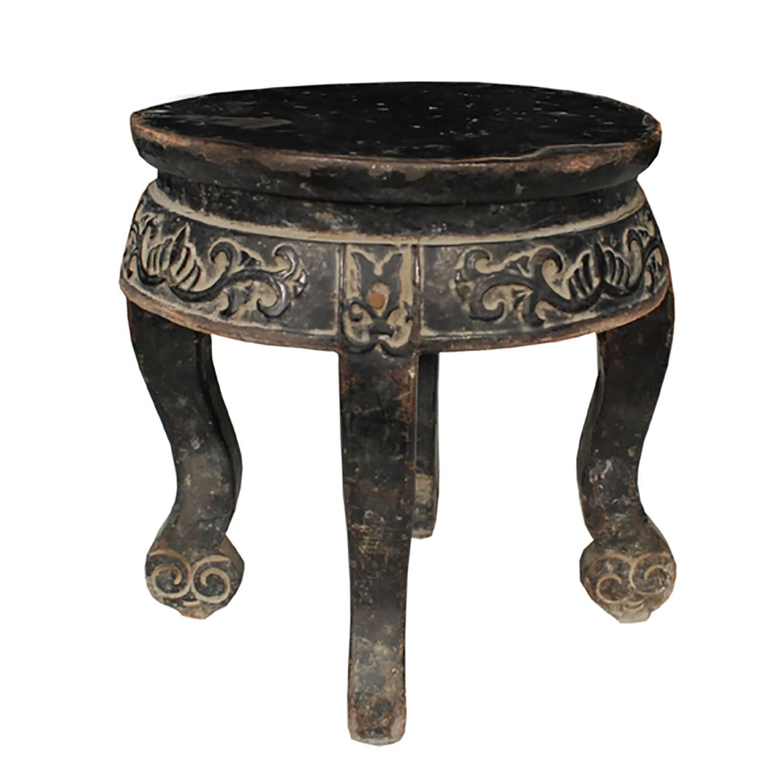 This petite round early 19th century display table from Northern China was hand-carved out of northern elm. It was likely used to support a ritual or decorative object. It features gentle cabriole legs that end in abstract auspicous cloud ruyi,