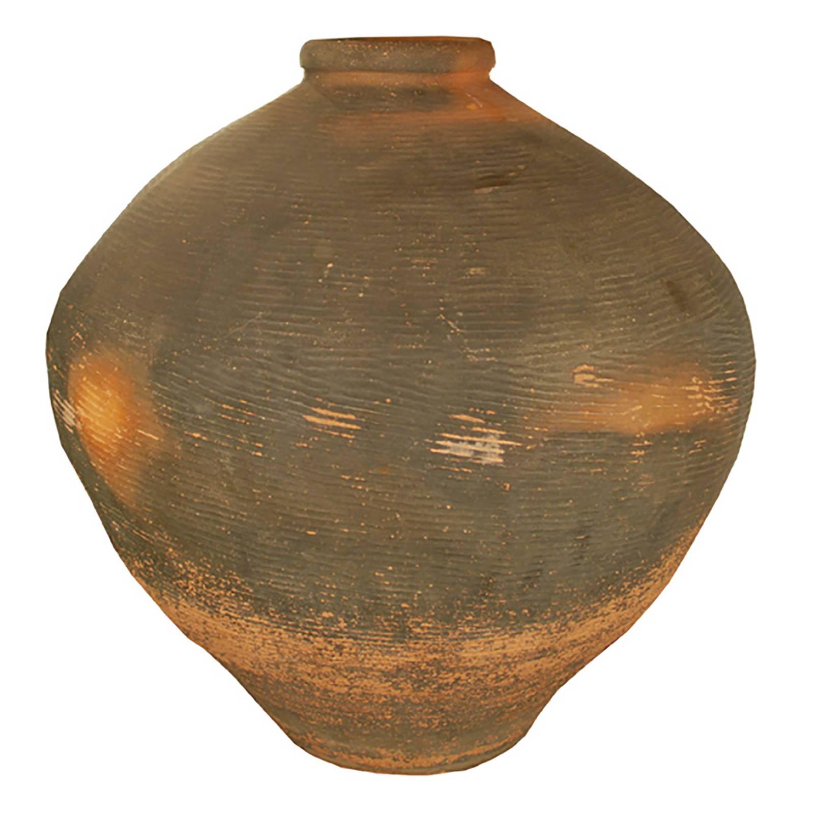 Shaped according to millennia-old prototypes fired in the Bronze Age, this handmade ceramic jar from northern China once stored wine and spirits made from rice and grains. Stunning in the garden or poised as a floor vase, this vessel possesses