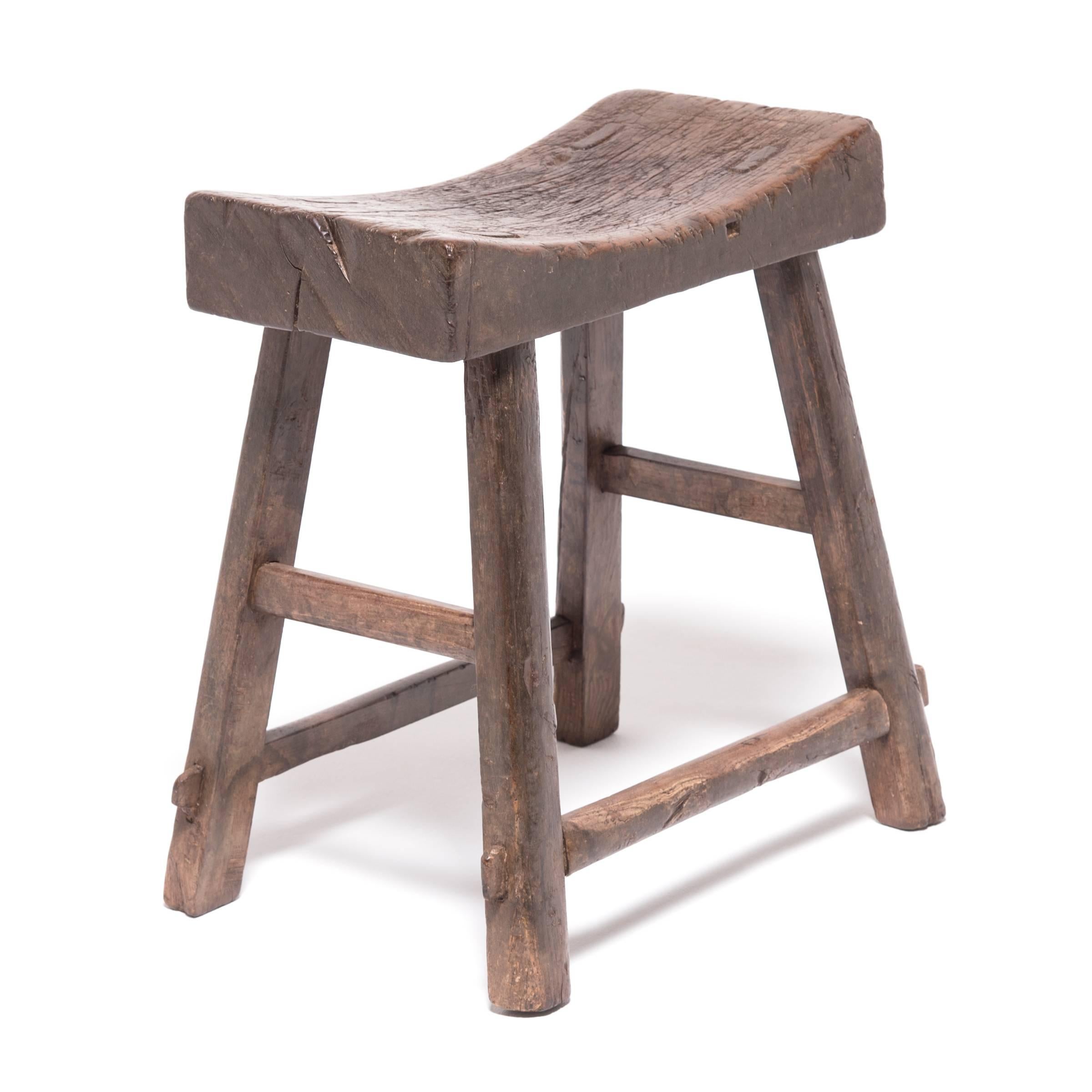 Dynamic and fluid, this Qing-dynasty stool shapes a crescent-curved seat supported by a network of angle legs and horizontal stretcher bars. Made of northern elmwood, the simple yet sculptural stool has aged beautifully with rich character and great