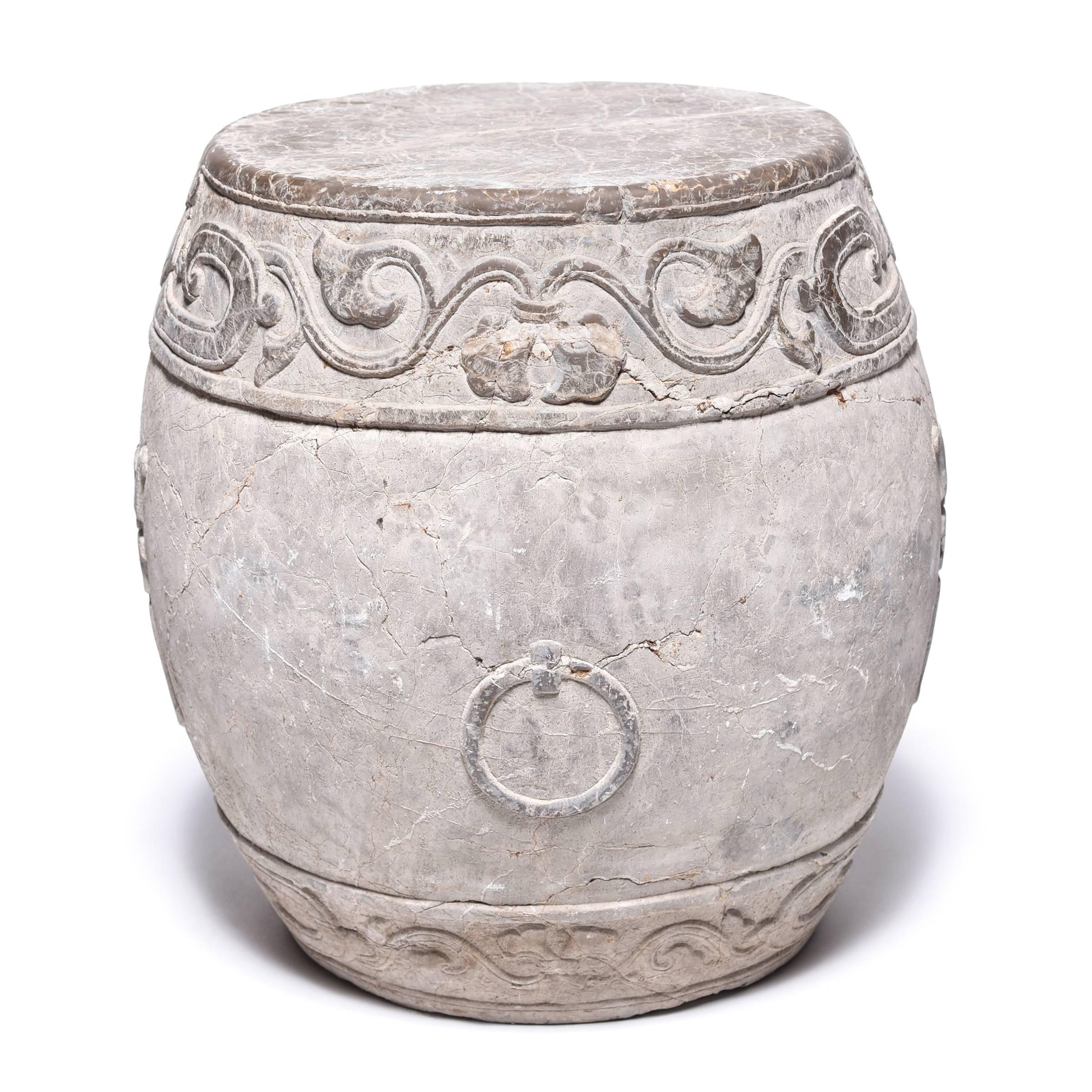 Made in Shanxi province, this venerable drum stone was hand-carved with a trailing vine motif and an auspicious “fu” character representing prosperity. The stone is lightly polished to accentuate the relief carvings and provide a smooth top for use