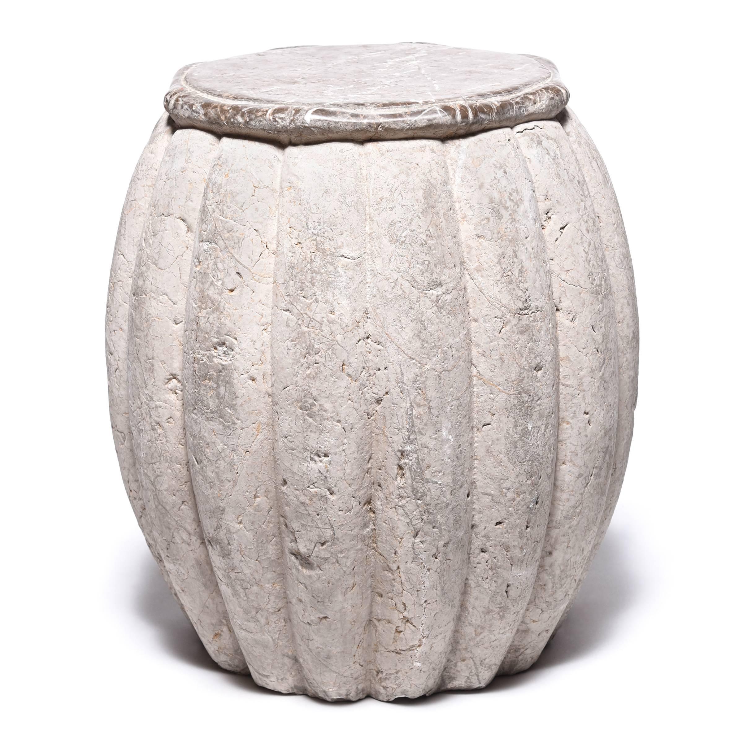 Hand-carved from limestone, this drum-shaped stool swells a ribbed melon shape, an ancient symbol of fertility. A smooth top with bamboo-like trim juxtaposes nicely with the drum’s organic grain and markings, while providing a level surface. We love