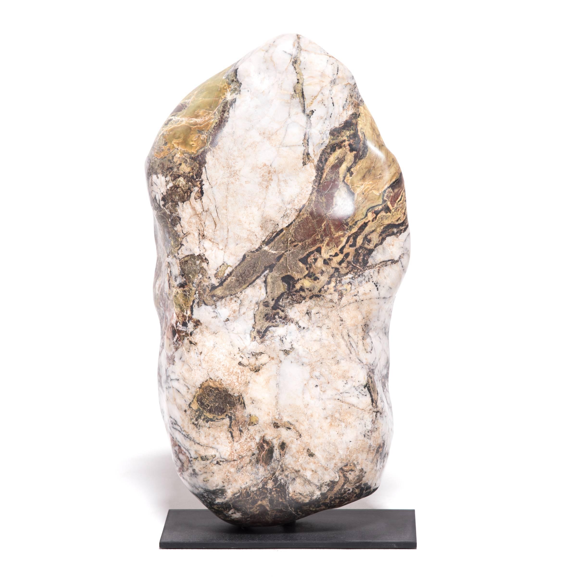 Brimming with gestural swaths of jade and intricate veining, this gorgeous meditation stone, known as Chinese colorful stone, invites contemplation of nature’s infinite creativity. Imaginative landscapes, figures and otherworldly apparitions come