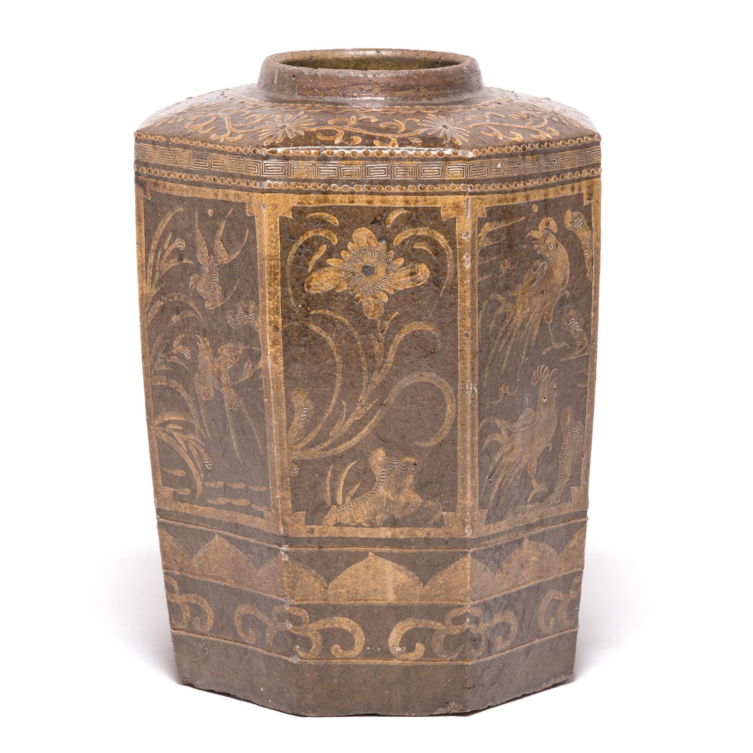 This 19th century eight-sided glazed urn from Southern China was finely painted with auspicious animals, including a crane, representing divine communication and immortality. The monumental scale allows for fantastic detail of a multitude of natural