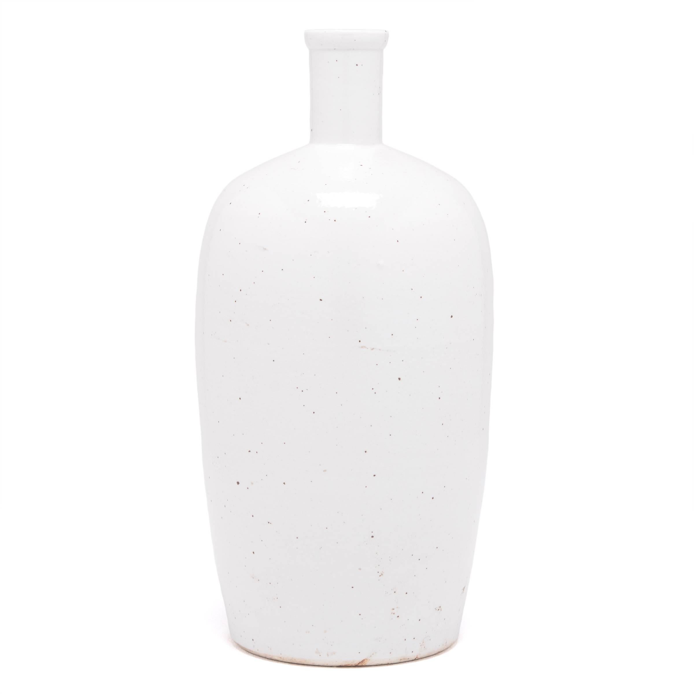 A milky white glaze emphasizes the simple, serene beauty of this contemporary ceramic. Crafted in Jiangxi province in 2015, the vessel refines the traditional bottle shape with clean lines and an understated sculptural presence.

 