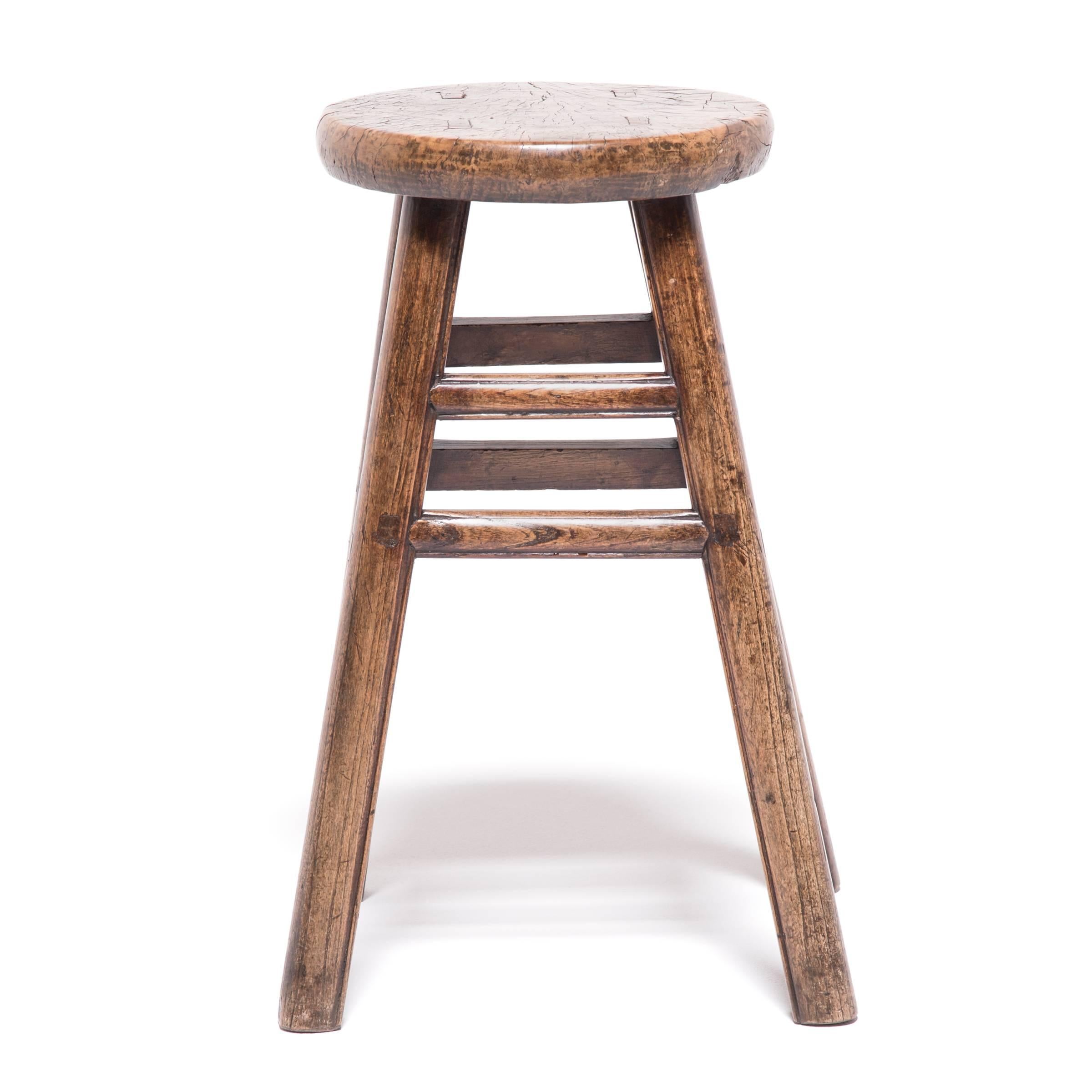 Like the full moon displaying its craters and ridges, the round seat of this otherwise straightforward stool displays the swirling grain and unusual markings of burled wood. Cultivated from irregular growths on trees, this type of wood is prized for