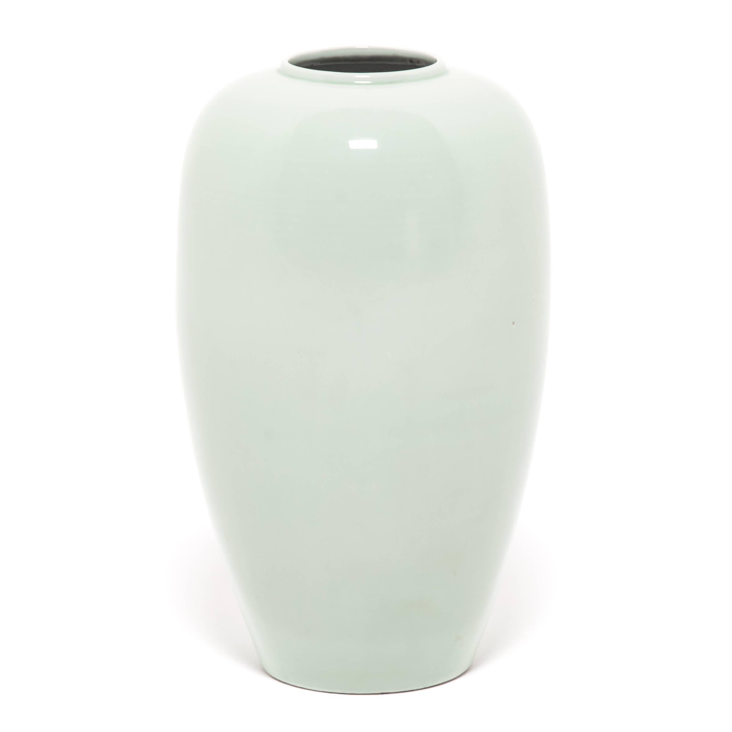 Collectors have coveted Celadon ceramics, like this vase with gentle proportions, for centuries. The glazing process is complex: an artisan covered the vase in liquid iron-rich clay, and then with a glaze that reacts to the iron to create this