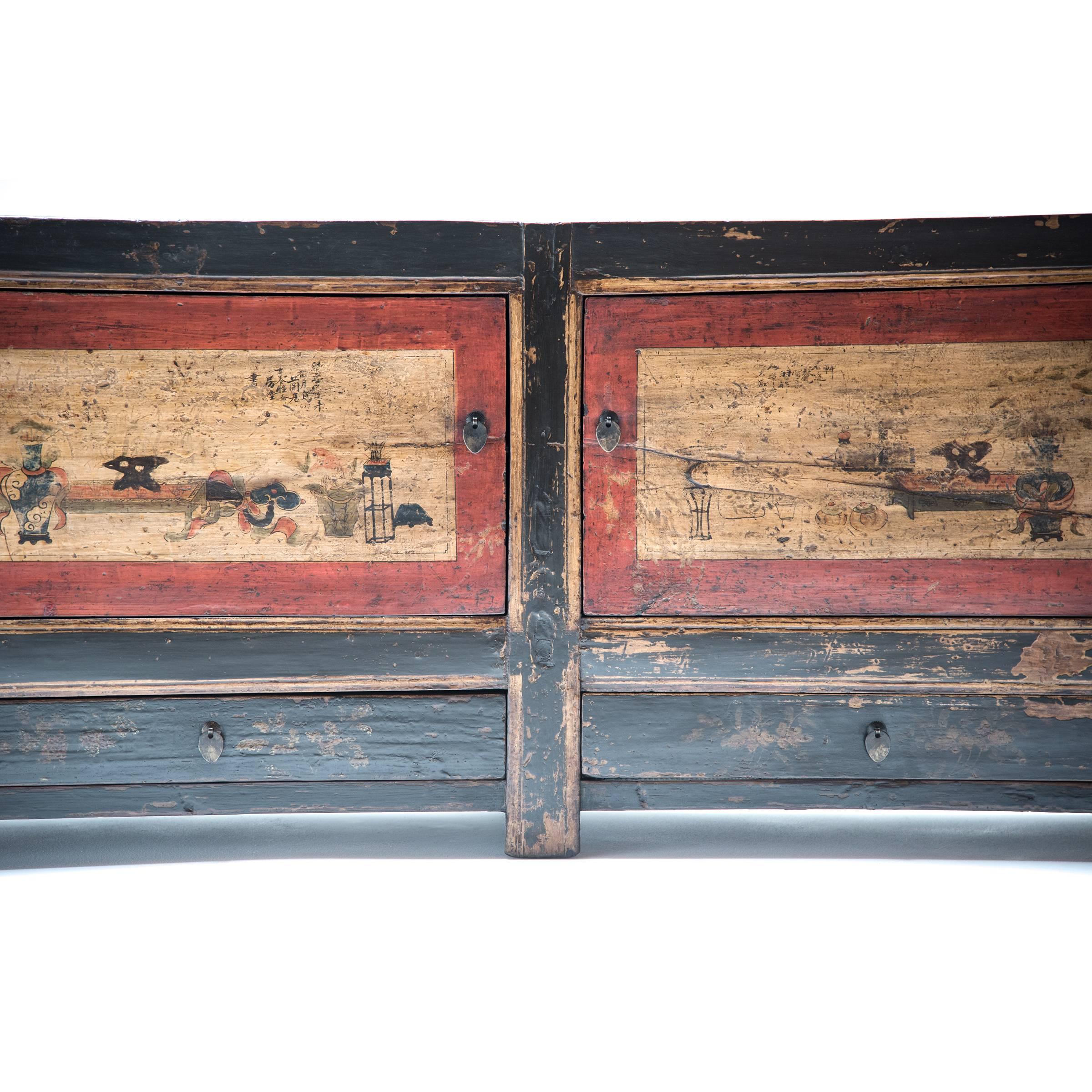 This handsome two-door, two-drawer cabinet was made long ago by a Mongolian artisan and can be appreciated for many years to come. It has a simple and subtle charm that is timeless: the original brass hardware, the hand painted scenes depicting a