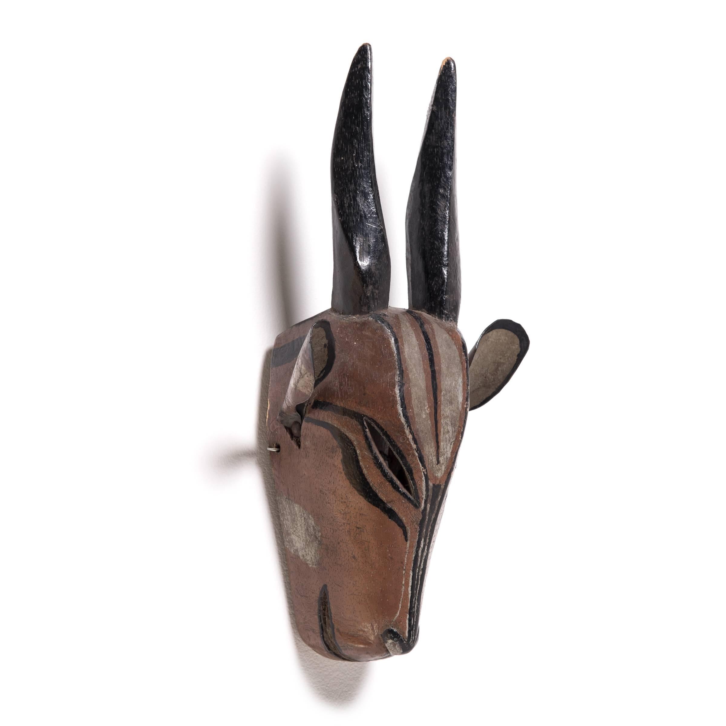 The fine finish and detail work on this antelope mask are hallmarks of the Igbo master craftspeople. The sleek, simplified form is evocative, calling to mind all the beauty and grace of the antelope in motion. The precise painting adds depth and