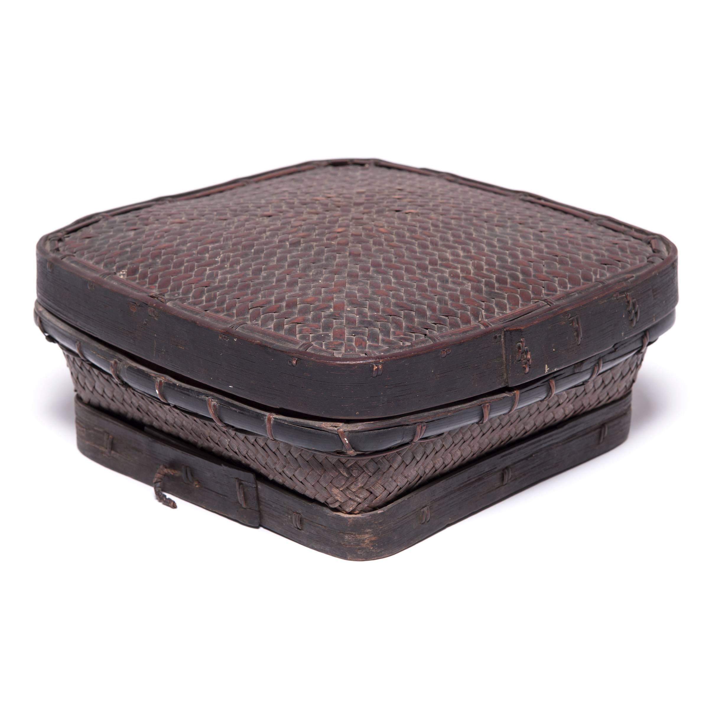 For centuries, basketry formed an essential part of all aspects of daily life in the Philippines. This covered basket, crafted of woven reed, bamboo and wood, may have been used to secure household items. Clothing and blankets, in particular, would