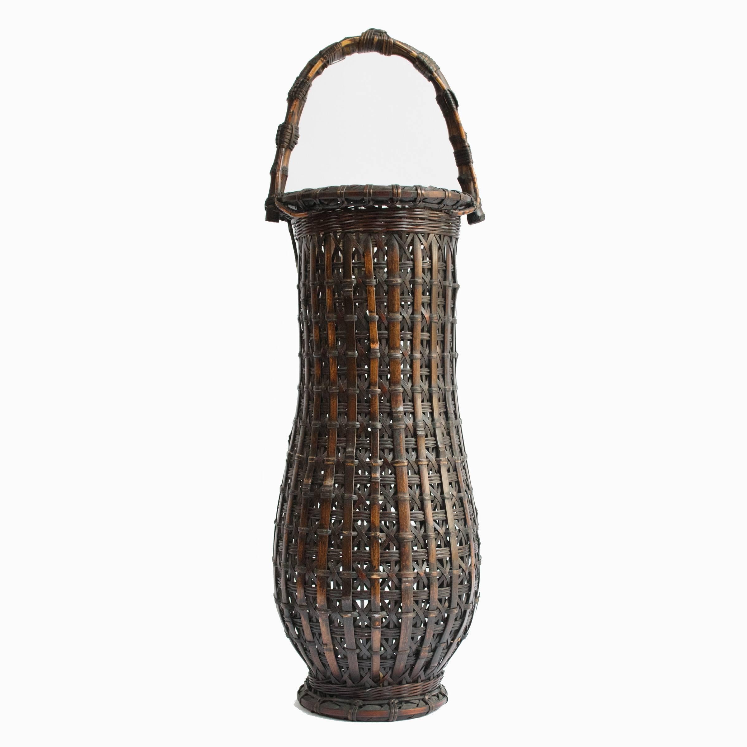 This one-of-a-kind bamboo basket was designed to hold ikebana: a very special Japanese flower arrangement. Looking at the detail of the weave at the very top of the handle, which resembles a knot, indicates that the artisan who made this basket was