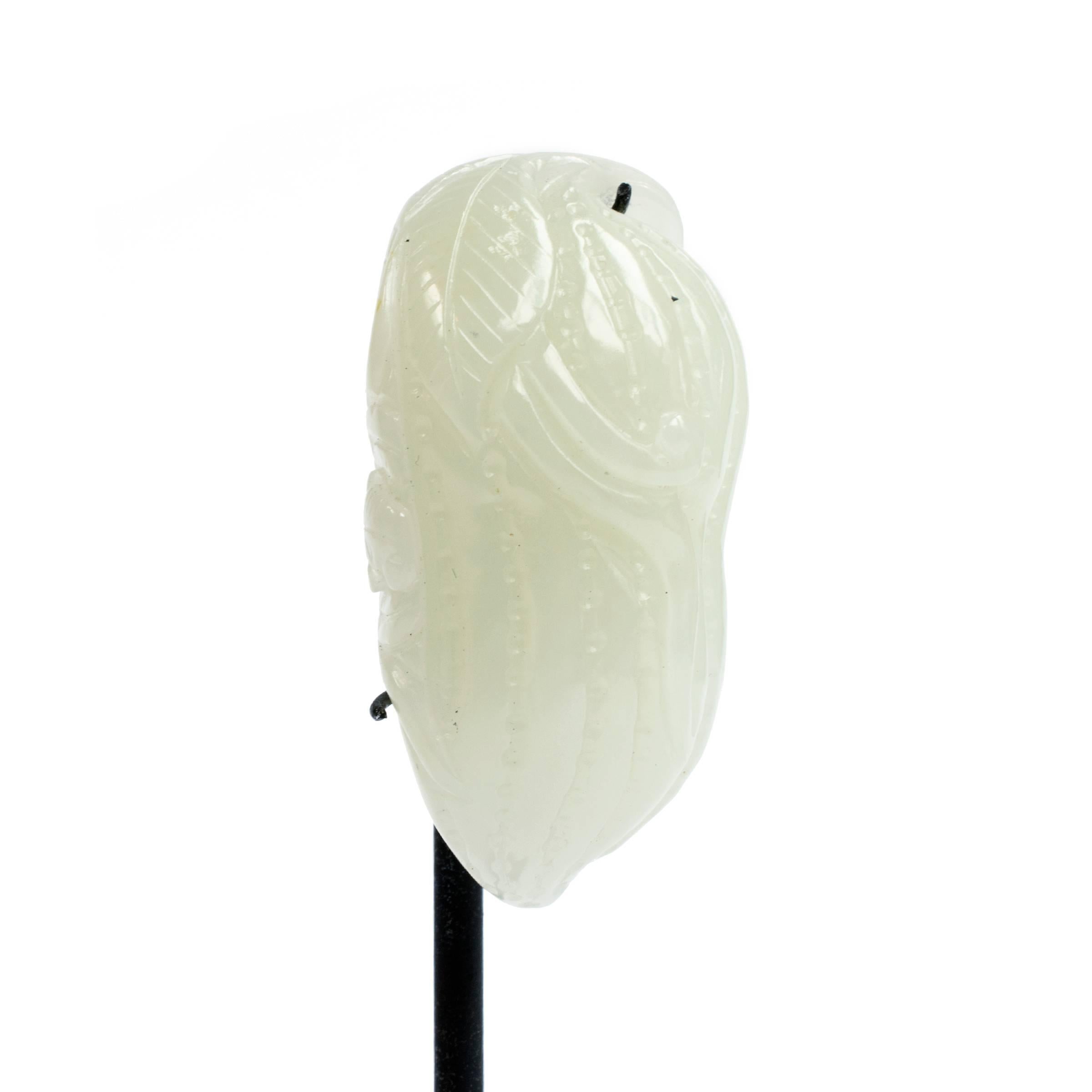 This finely crafted jade toggle is carved in the form of a melon with a leafy vine. Melons and gourds are auspicious Chinese symbols of virility because they contain many seeds. Like other finely carved toggles, such a charm would have been prized