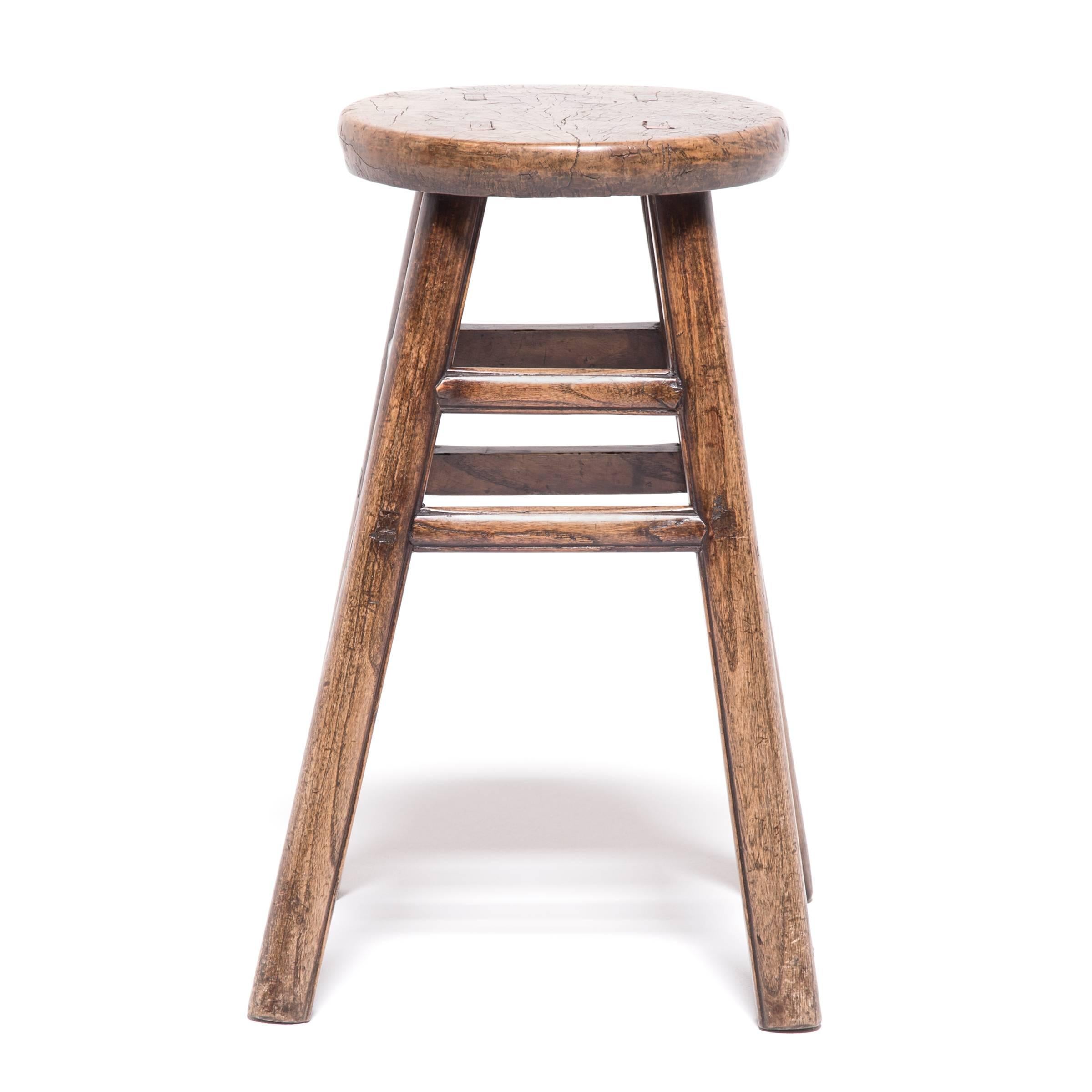 Like the full moon displaying its craters and ridges, the round seat of this otherwise straightforward stool displays the swirling grain and unusual markings of burled wood. Cultivated from irregular growths on trees, this type of wood is prized for