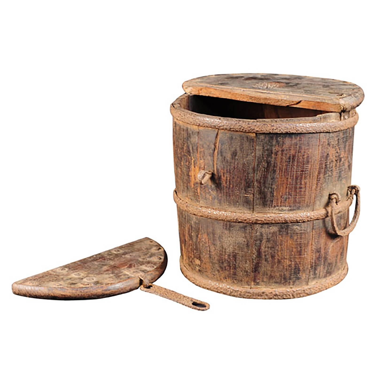 This early 19th century Chinese merchant's coin barrel is made from slats of wood strapped together with hand-wrought iron rings. Its form suggests it was originally intended for other uses, but an enterprising merchant saw its potential and carved