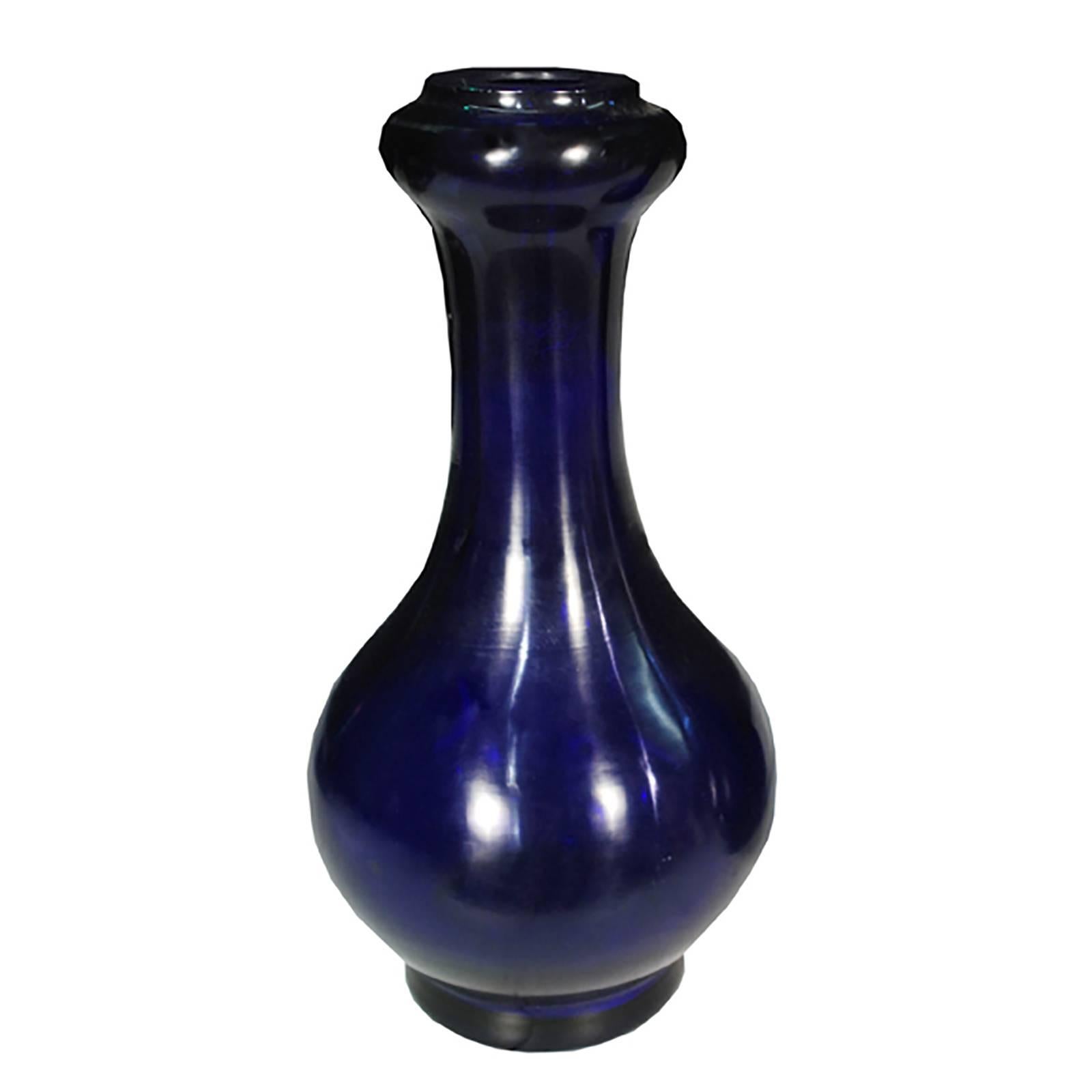 Artisans created this pair of early 20th century cobalt Peking glass vases using techniques developed hundreds of years ago in the Imperial workshops. The process involves hand-crafting layers and layers of molten glass and then carving and