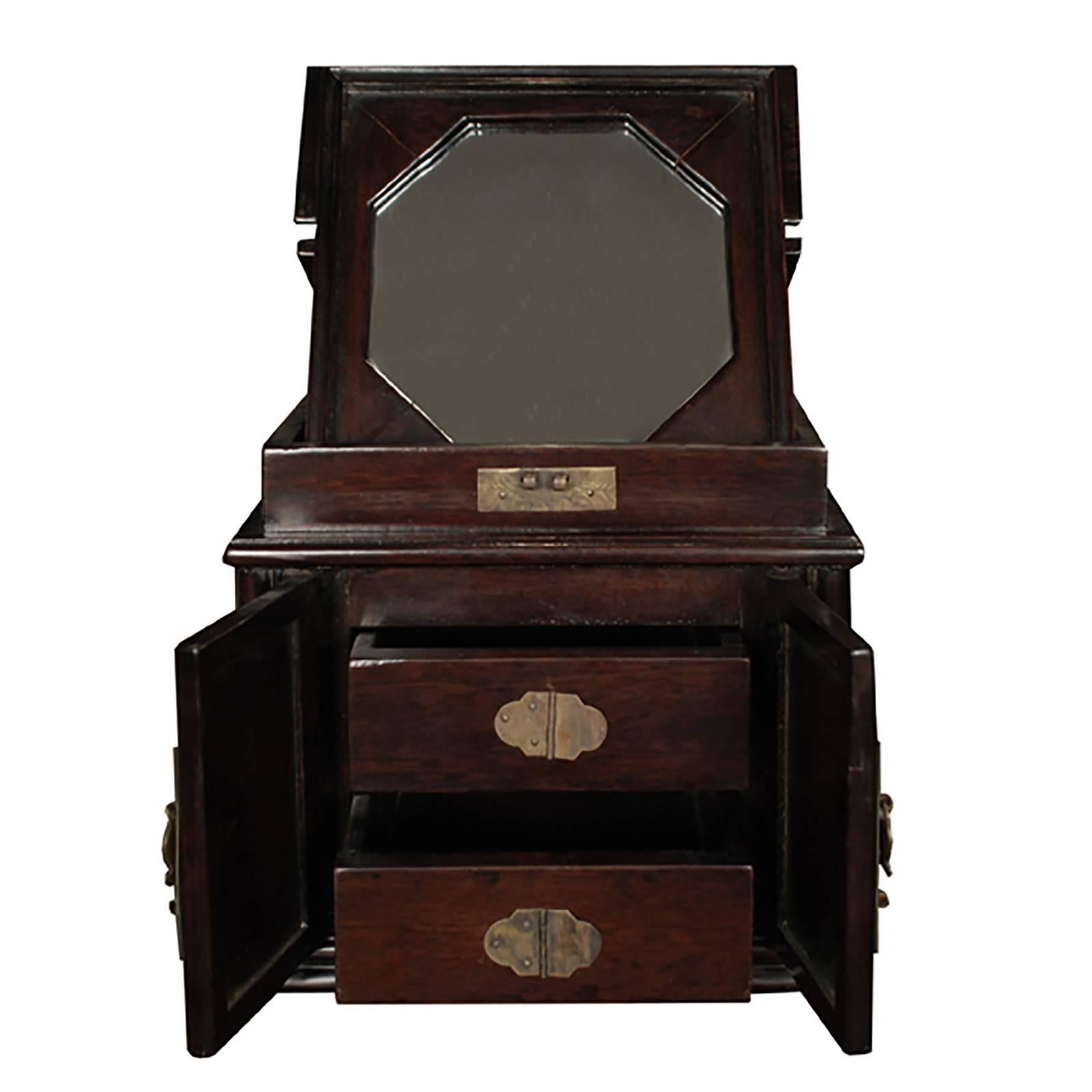 Original brass fittings detail this finely crafted rosewood vanity box. Thoughtfully designed at the turn of the century with a hinged top to conceal an octagonal mirror within, this petite box has beautifully detailed panels on its doors and small